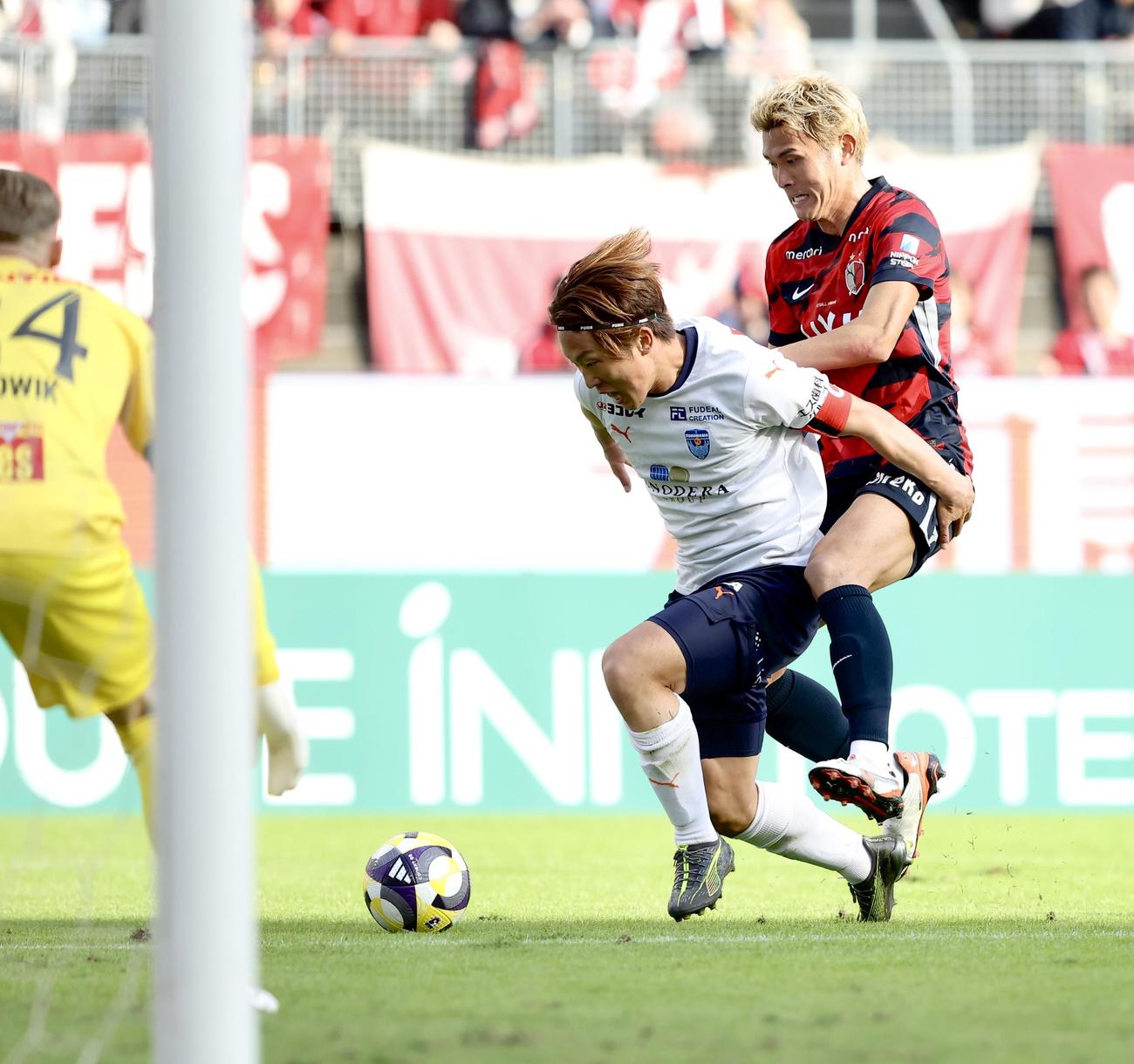 鹿島対横浜FC　前半、ゴール前で競り合う横浜FC岩武（左）と鹿島田川（撮影・河田真司）