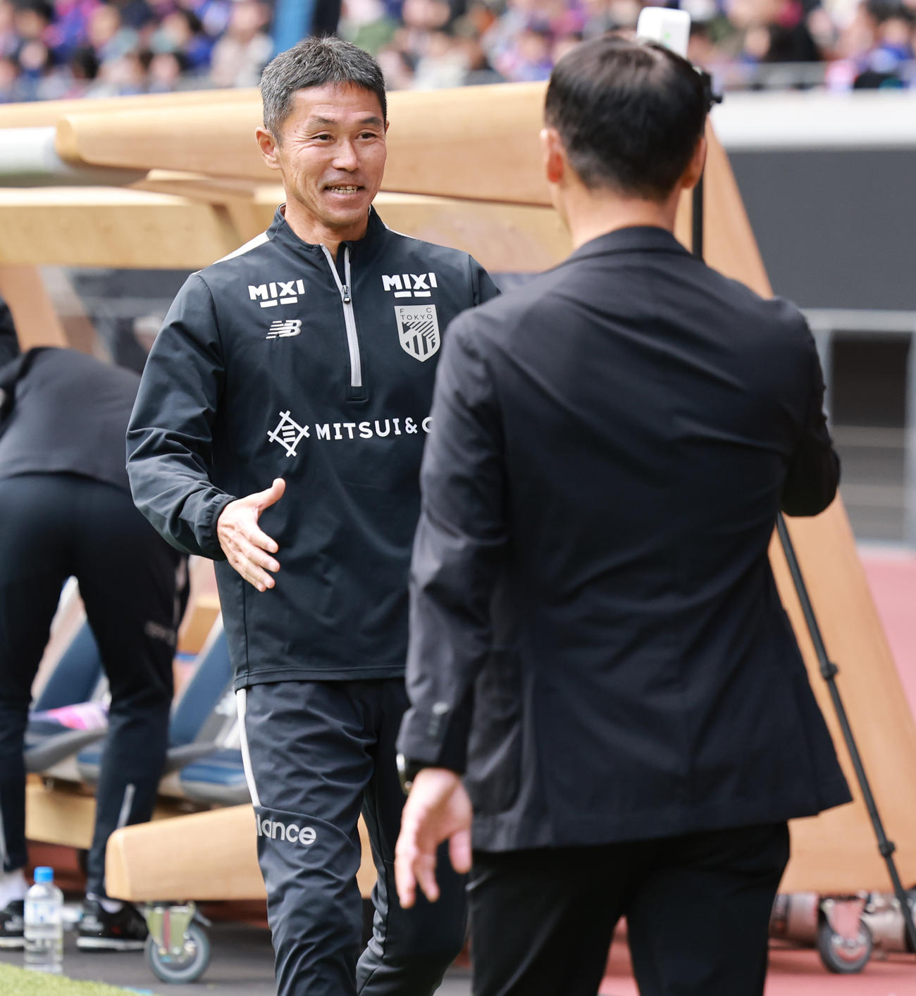 町田対東京　試合前に町田黒田監督（手前）とあいさつを交わす東京松橋監督（撮影・野上伸悟）