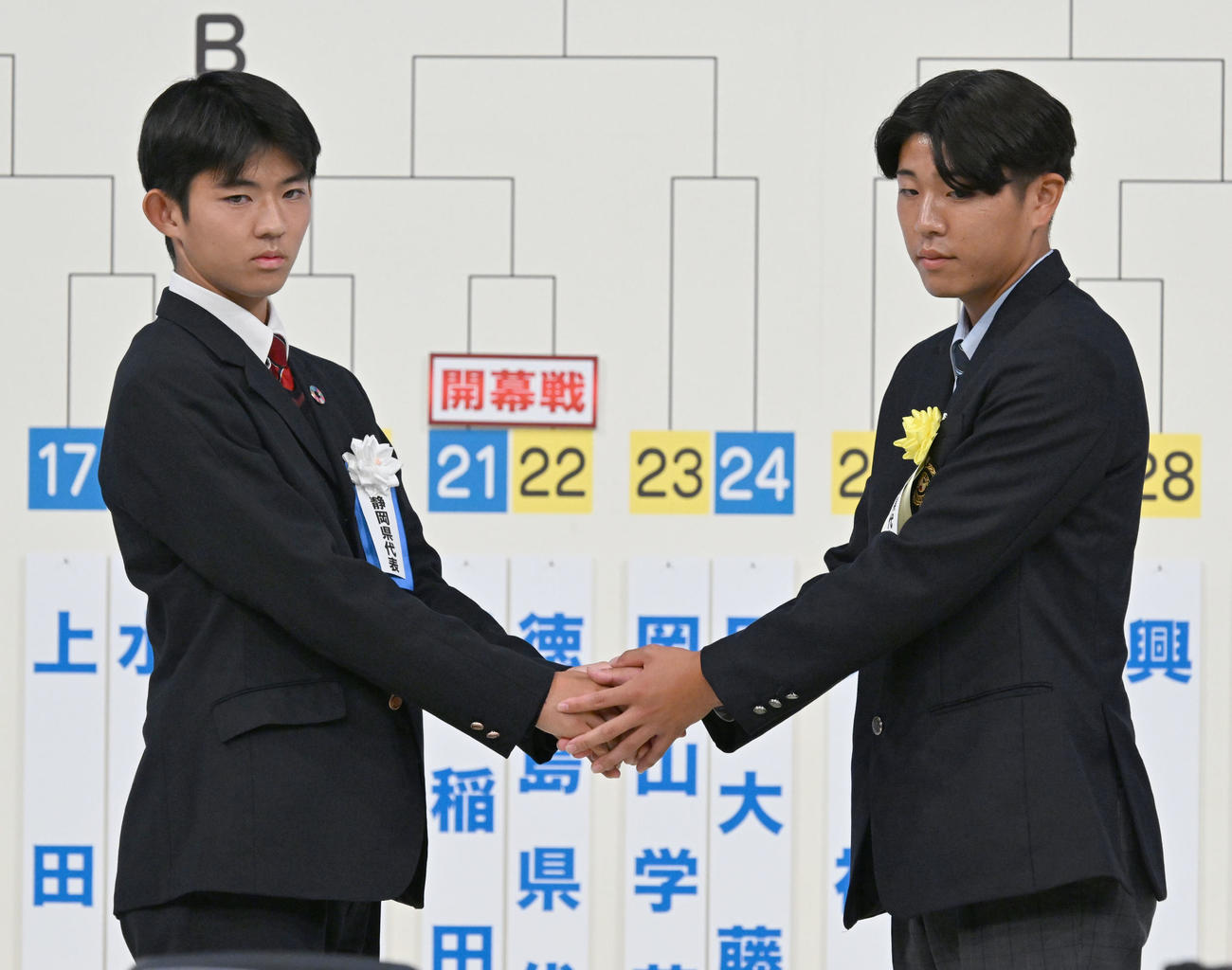 第104回全国高校サッカー選手権の組み合わせ抽選会で、対戦が決まり握手する浜松開誠館の川合主将（左）と九州文化学園の松本主将（撮影・千葉一成）