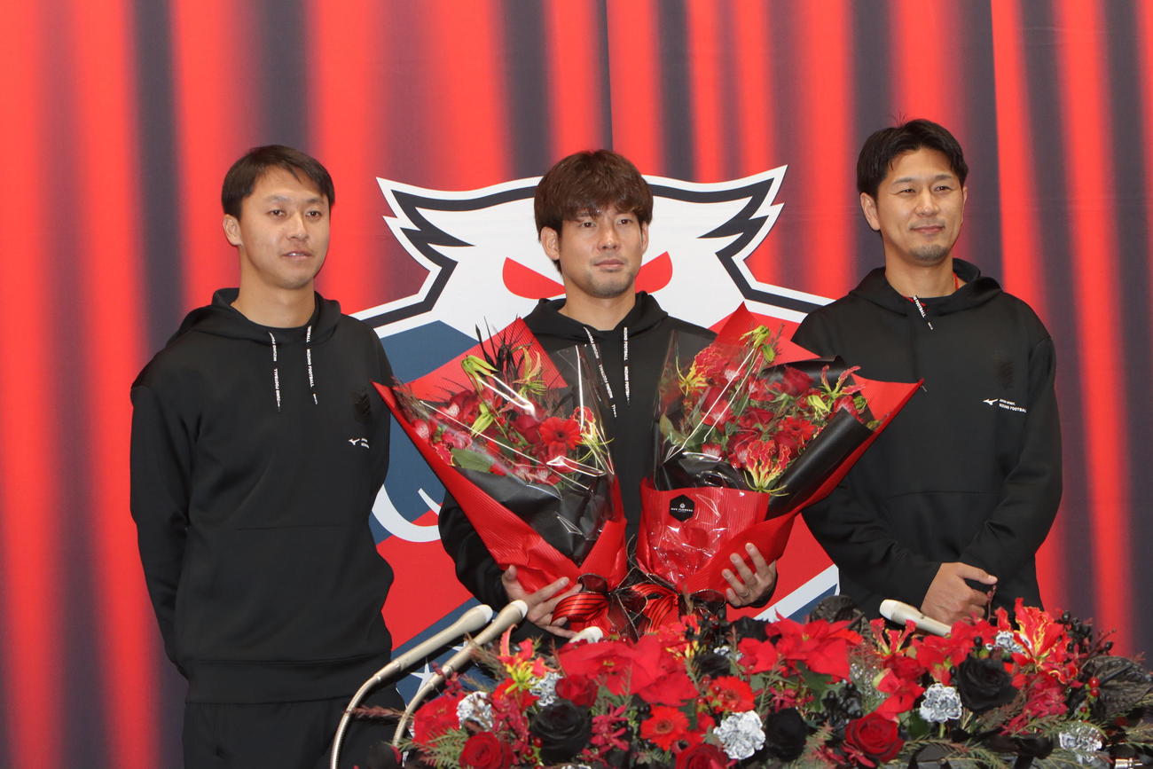札幌対愛媛　引退会見でチームメートの荒野（左）、宮沢（右）から花束を受け取る札幌深井（中央）（撮影・奥村晶治）