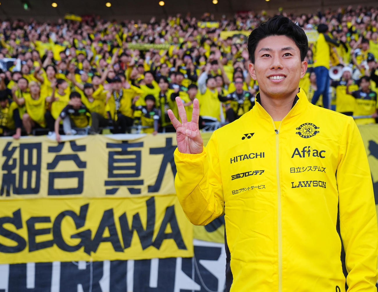 新潟対柏　新潟に勝利しサポーターを背に笑顔で写真に納まる柏細谷（撮影・垰建太）