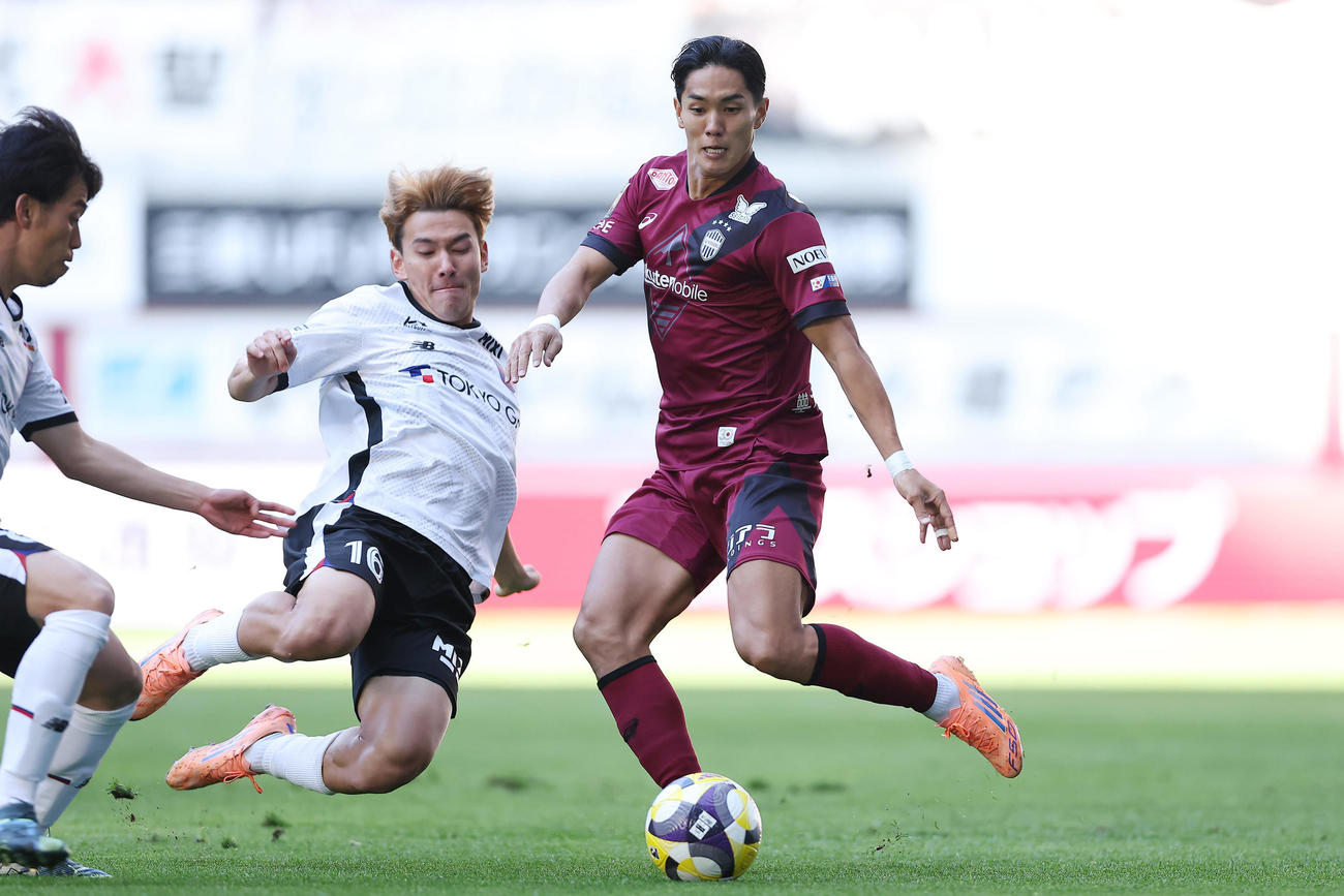 神戸対東京　前半、パスを出す神戸武藤（右）。左は東京佐藤（撮影・前田充）