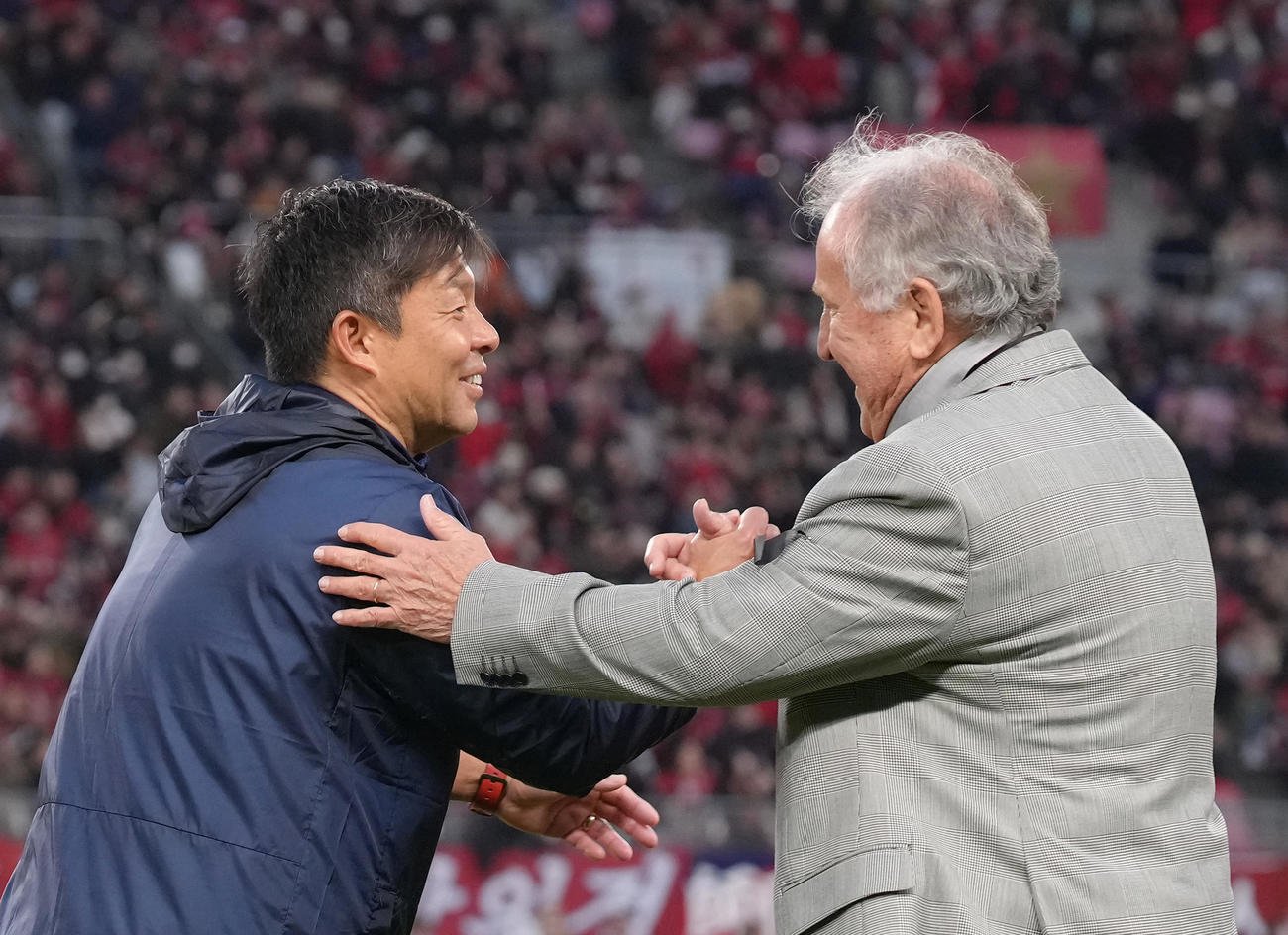 リーグ優勝した鹿島鬼木監督（左）はジーコ氏と笑顔で握手を交わす（撮影・足立雅史）