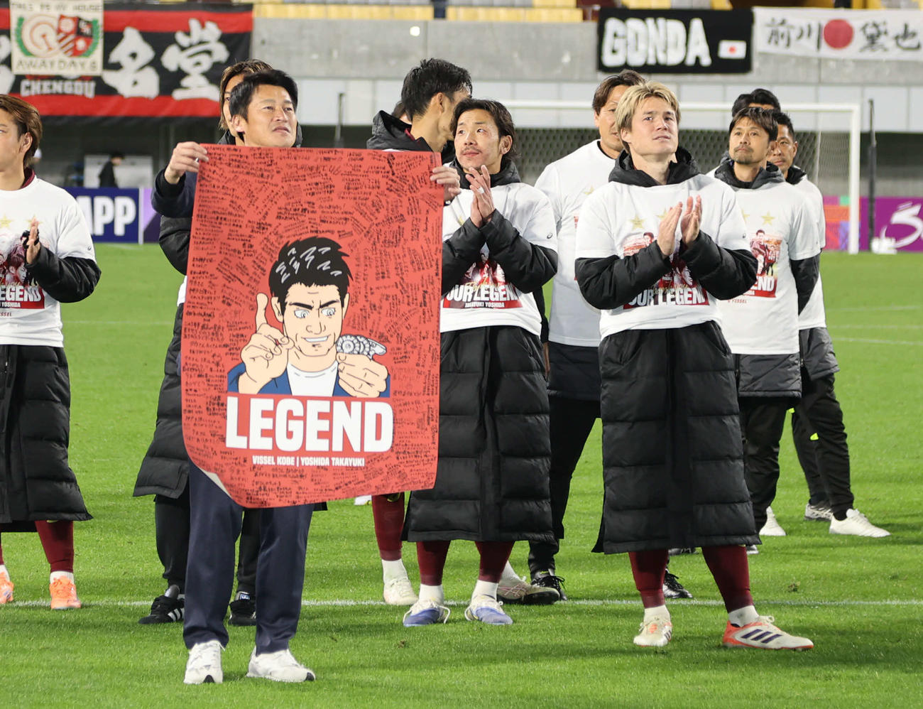 神戸対成都蓉城　神戸で最後の指揮を執った吉田監督は寄せ書き入りのポスターをサポーターに見せる（撮影・西尾就之）