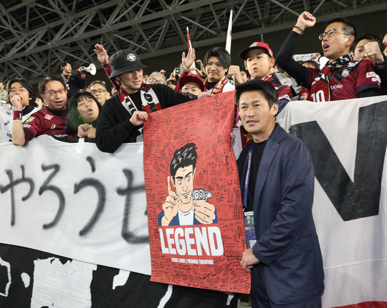 神戸対成都蓉城　神戸で最後の指揮を執った吉田監督は寄せ書き入りのポスターを手にサポーターと記念写真に納まる（撮影・西尾就之）