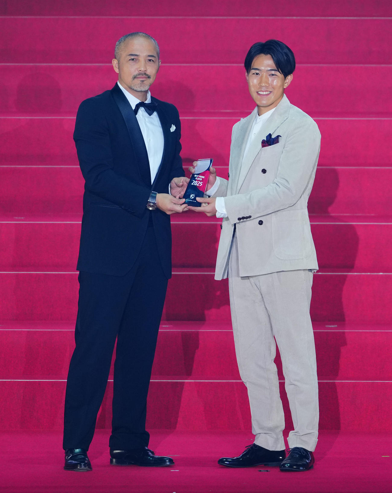 2025Jリーグアウォーズでベストヤングプレーヤー賞に選ばれた岡山佐藤（右）は小野氏と写真に納まる（撮影・垰建太）