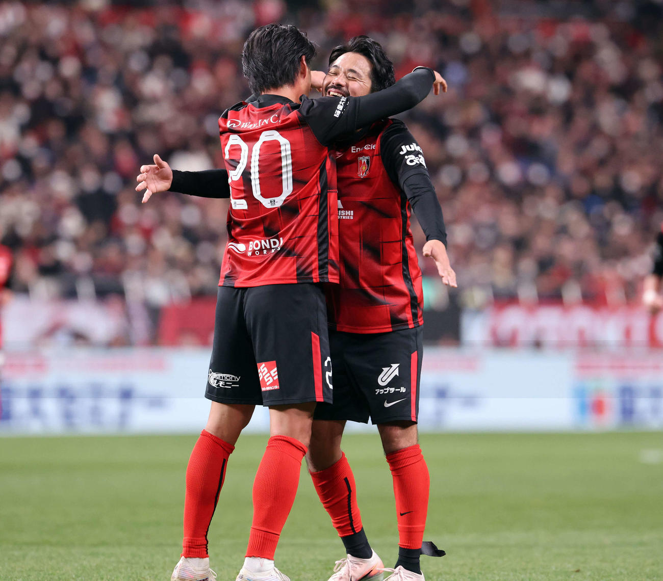 興梠慎三引退試合　浦和対鹿島　試合終了間際にゴールを決めた浦和李忠成さん（左）と抱擁で喜ぶ興梠慎三さん（撮影・浅見桂子）