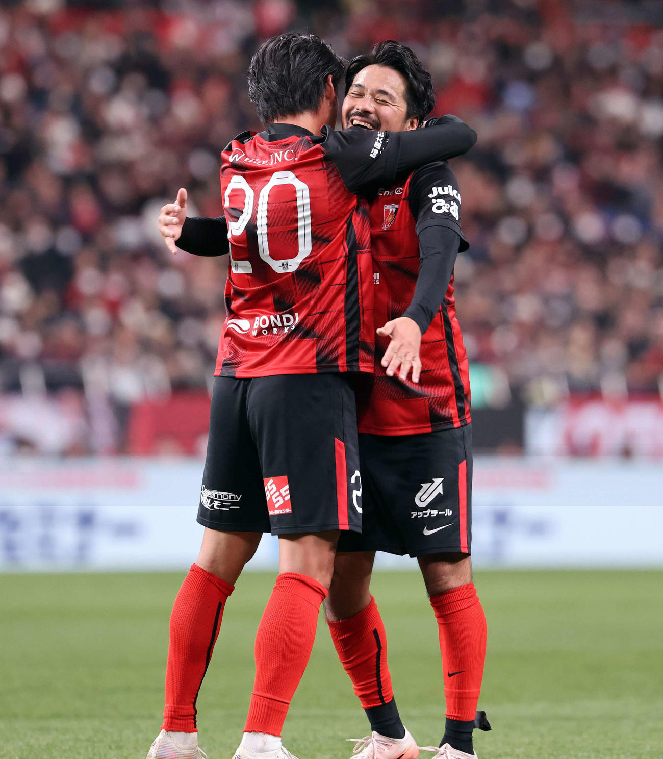 興梠慎三引退試合　浦和対鹿島　試合終了間際にゴールを決めた浦和李忠成さん（左）と抱擁で喜ぶ興梠慎三さん（撮影・浅見桂子）