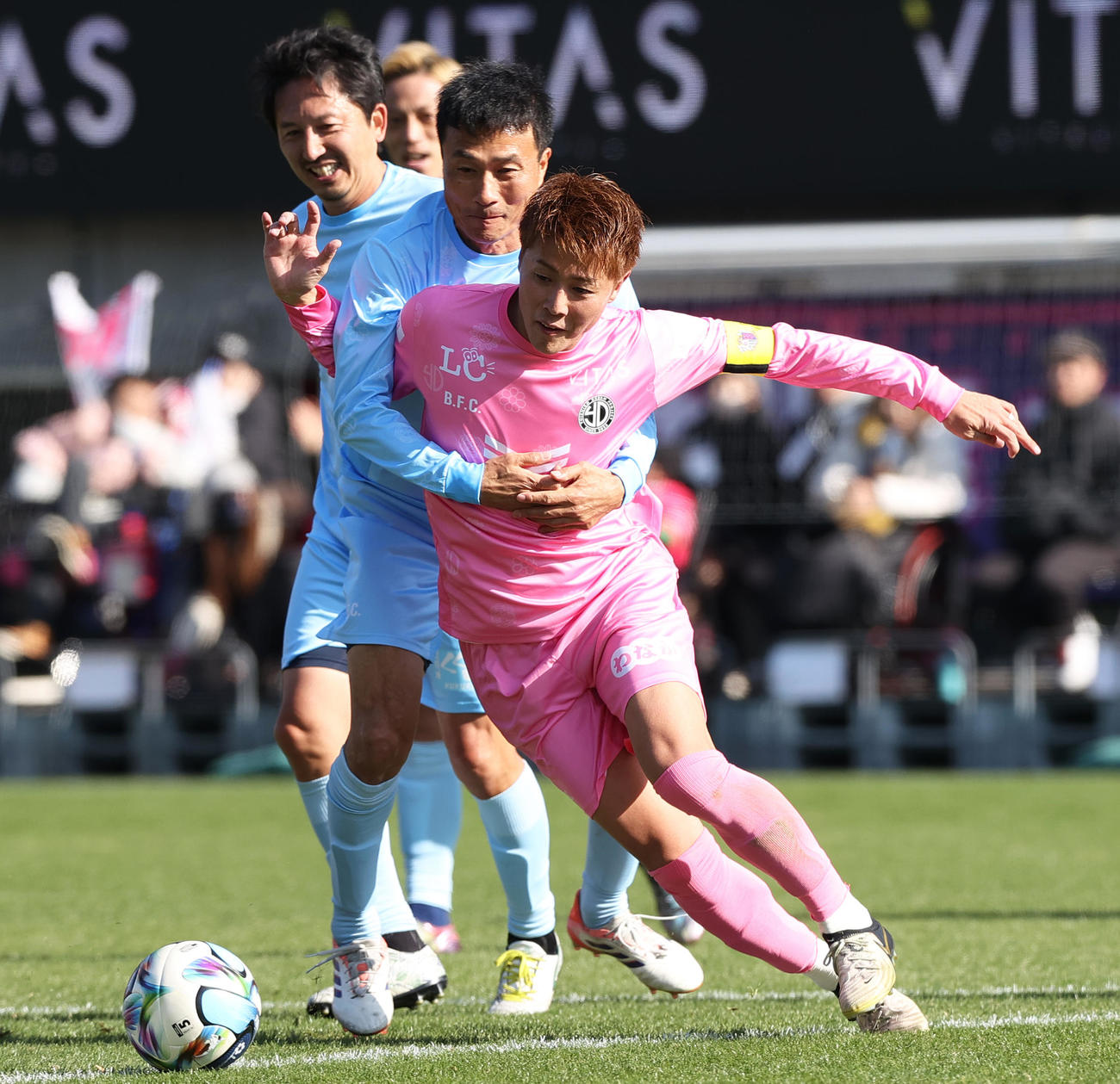 OSAKA PINK対OSAKA BLUE　前半、OSAKA PINK柿谷（手前）はOSAKA BLUE今野から激しいマークを受けながらドリブルで攻め上がる（撮影・上山淳一）