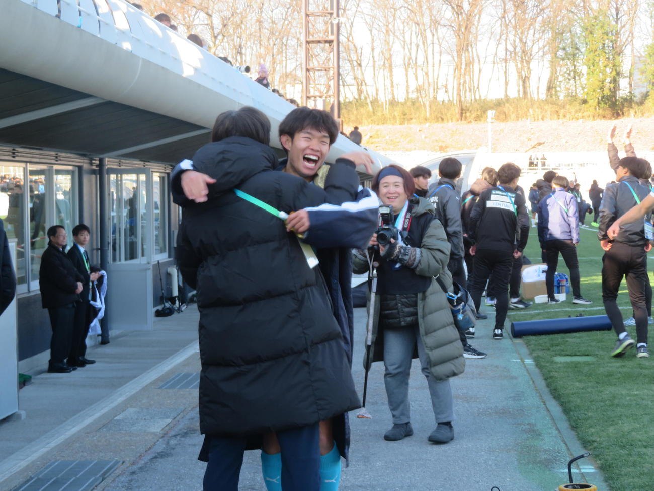 第74回全日本大学サッカー選手権で優勝した筑波大の徳永涼と抱き合う中西哲生テクニカルアドバイザー（撮影・佐藤成）