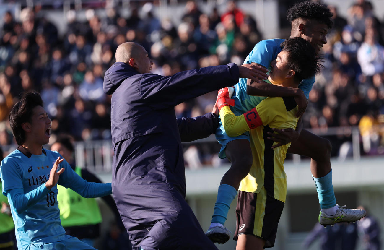 山梨学院対京都橘　PK戦で勝利し抱き合って喜ぶ山梨学院イレブン。右はGK石井（撮影・水谷安孝）