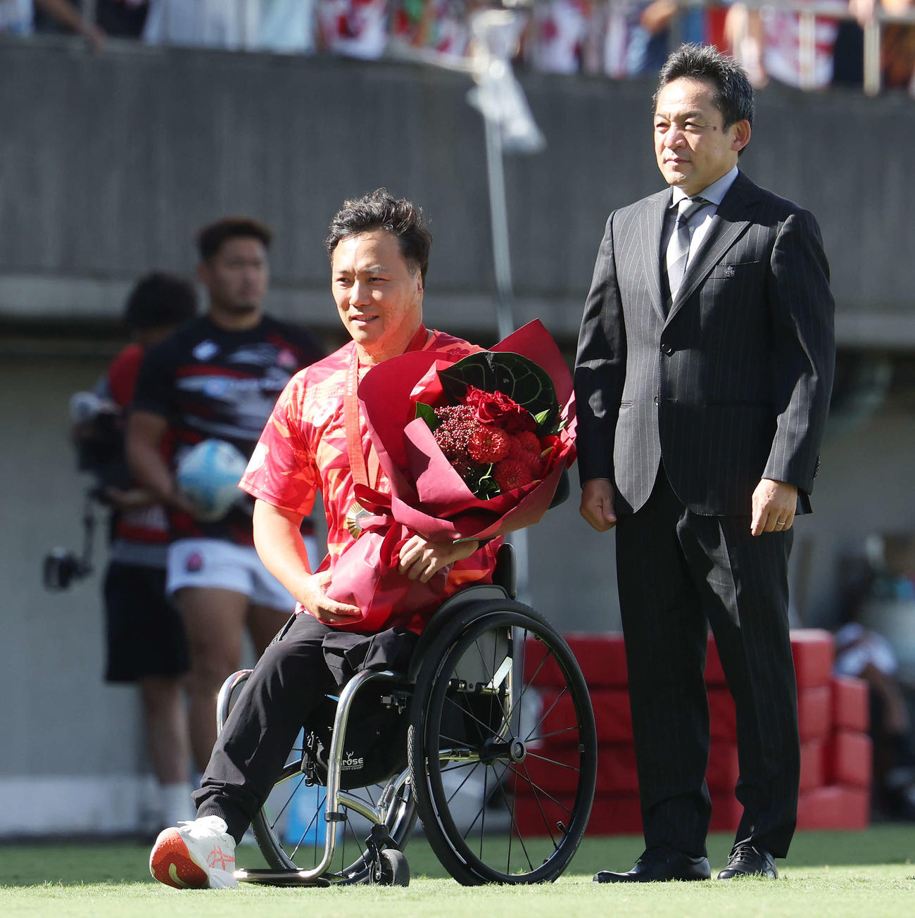 男子15人制日本代表の永友ディレクター（右）から花束が贈られた車いすラグビー日本代表金メダリスト池主将（2024年9月撮影）