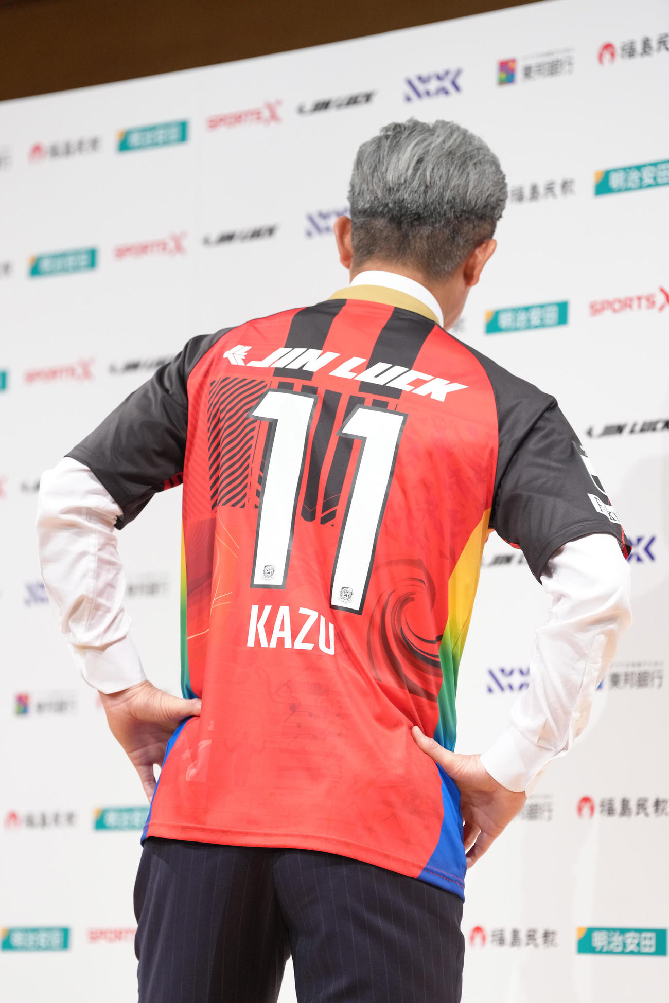 J3福島加入会見で背番号11を披露するカズ（撮影・足立雅史）