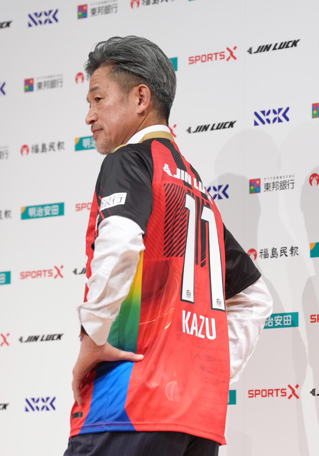 J3福島加入会見で背番号11を披露するカズ（撮影・足立雅史）