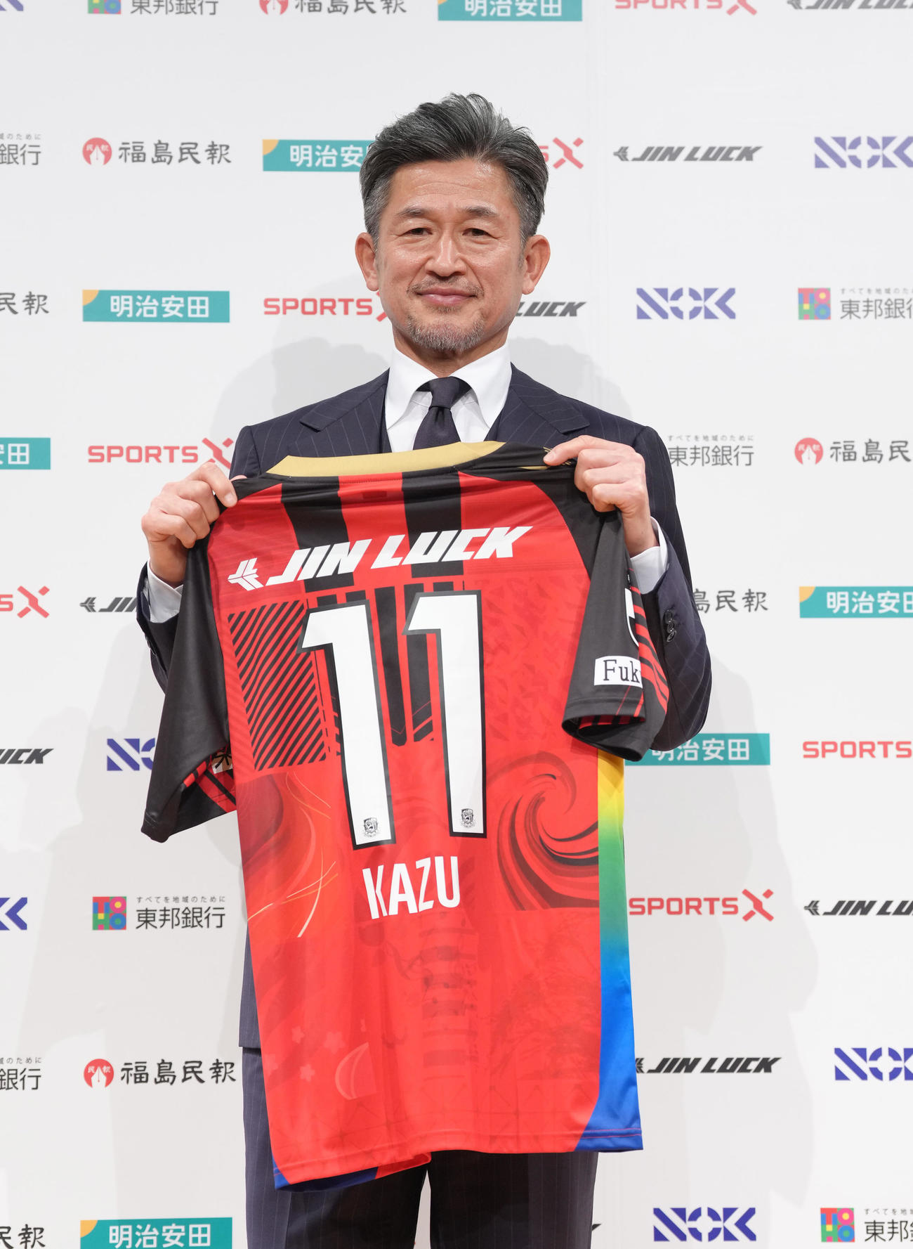 J3福島加入会見で背番号11を披露するカズ（撮影・足立雅史）