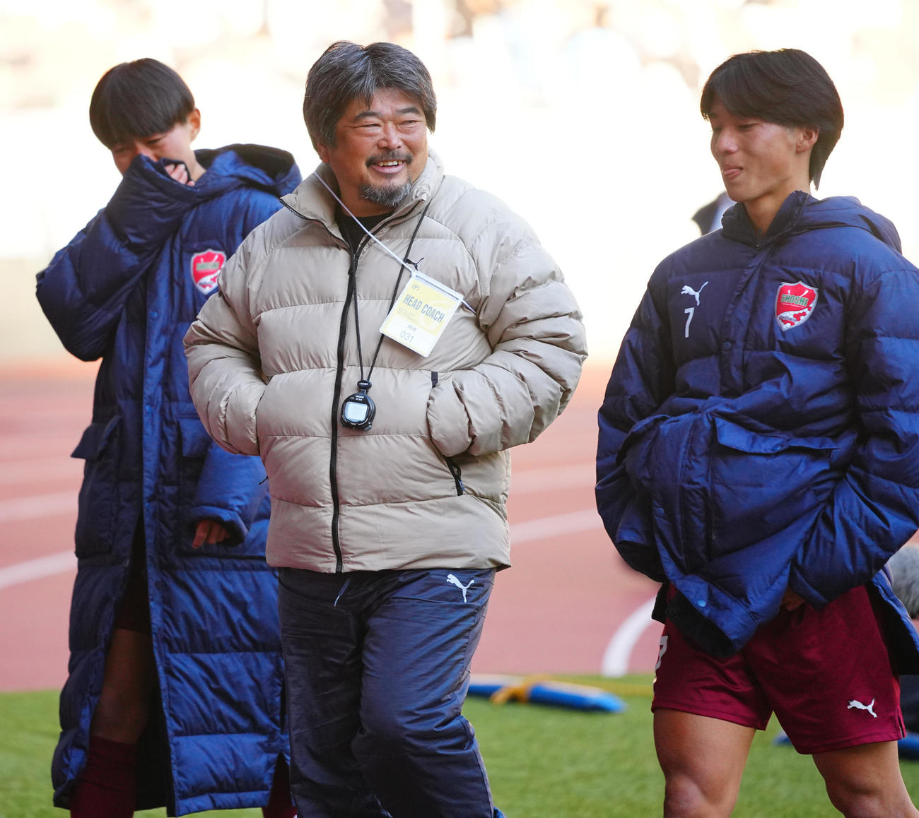 尚志対神村学園　PK戦の末に敗れた選手たちと笑顔を見せながら引き揚げる尚志・仲村監督（中央）（撮影・垰建太）