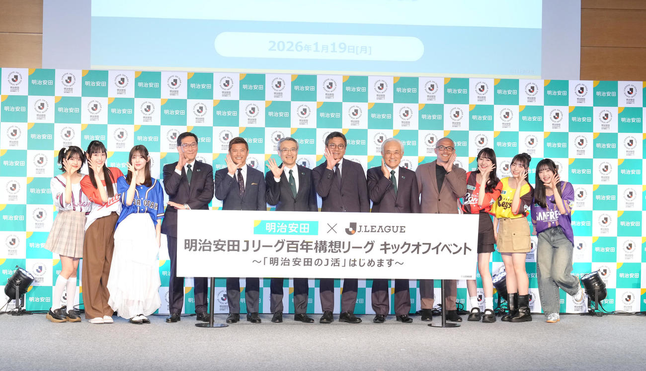 「ニコラポーズ」を決める、左から安藤美桜、十文字陽菜、松尾そのま、明治安田生命中村篤志副社長、播戸氏、明治安田生命永島英器社長、Jリーグ野々村チェアマン、明治安田生命根岸秋男会長、小野氏、崎浜梨瑚、稲垣来泉、大月未空（撮影・足立雅史）