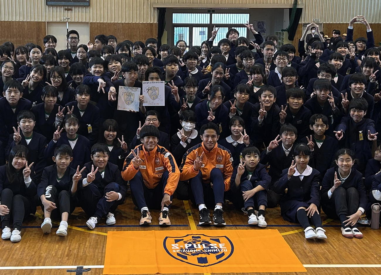 児童たちと記念写真に納まる清水土居（前列中央左）と針生（同右）