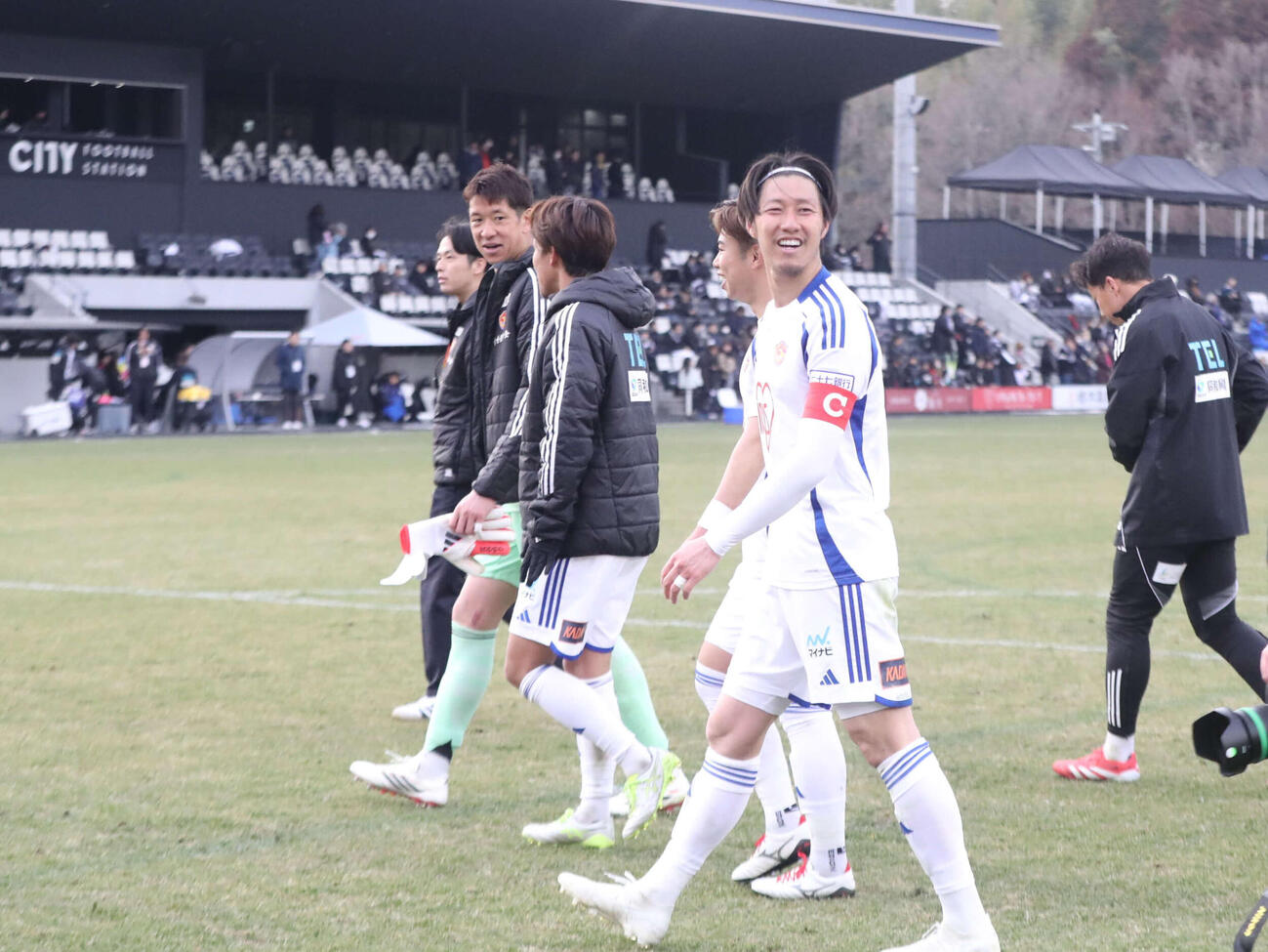 栃木シティ対仙台　勝利に喜ぶチームメートとサポーターを笑顔で見つめるDF菅田（撮影・高橋香奈）