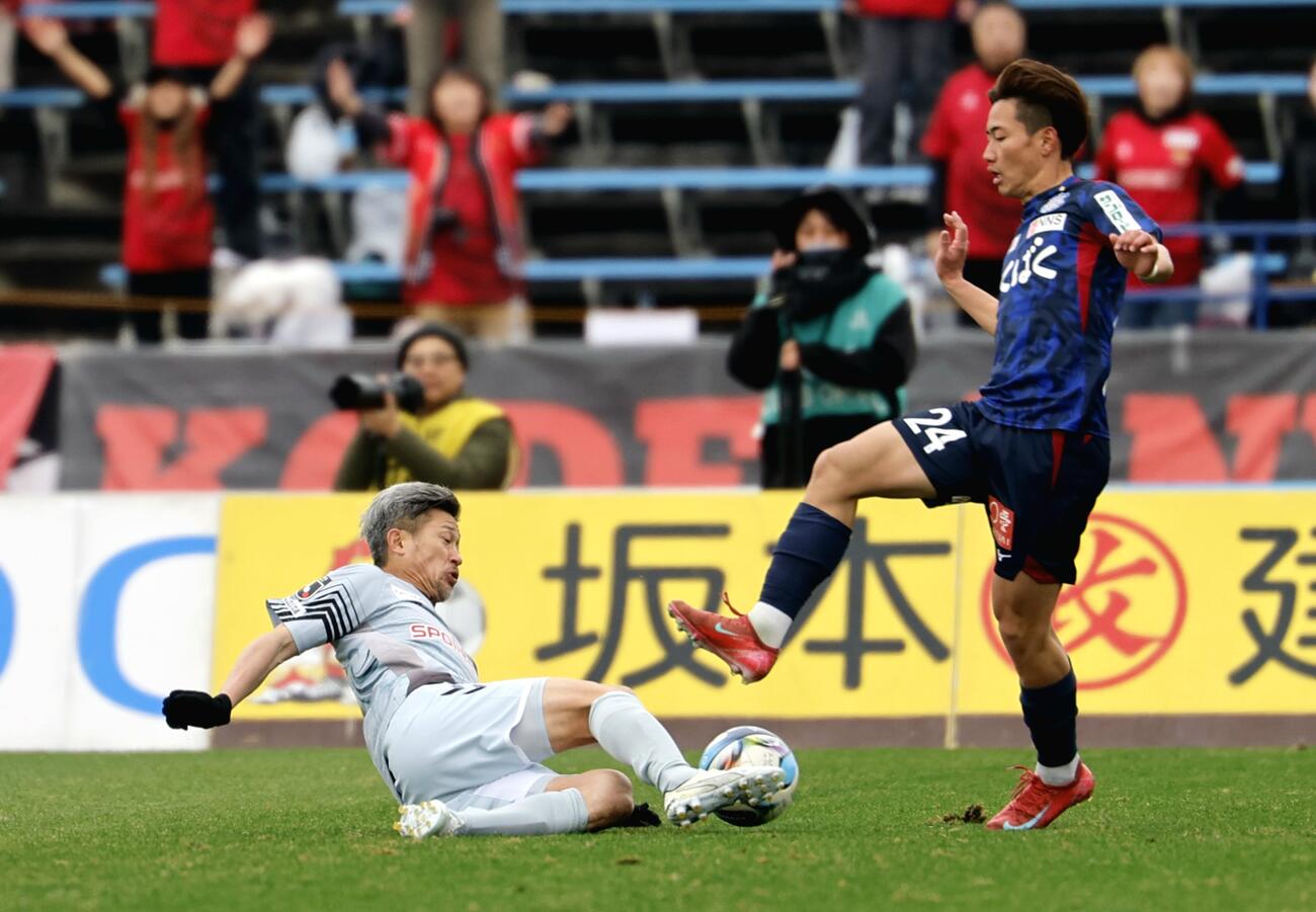甲府対福島　前半、スライディングタックルを仕掛ける福島カズ（左）（撮影・山本朝陽）