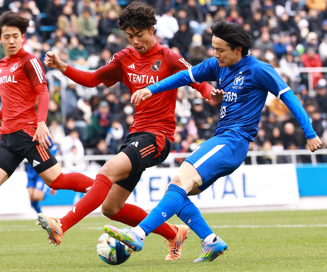 U－18Jリーグ選抜対日本高校サッカー選抜　前半、シュートを放つ日本高校サッカー選抜の帝京・宮本。左はU－18Jリーグ選抜の名古屋オディケチソン（撮影・野上伸悟）