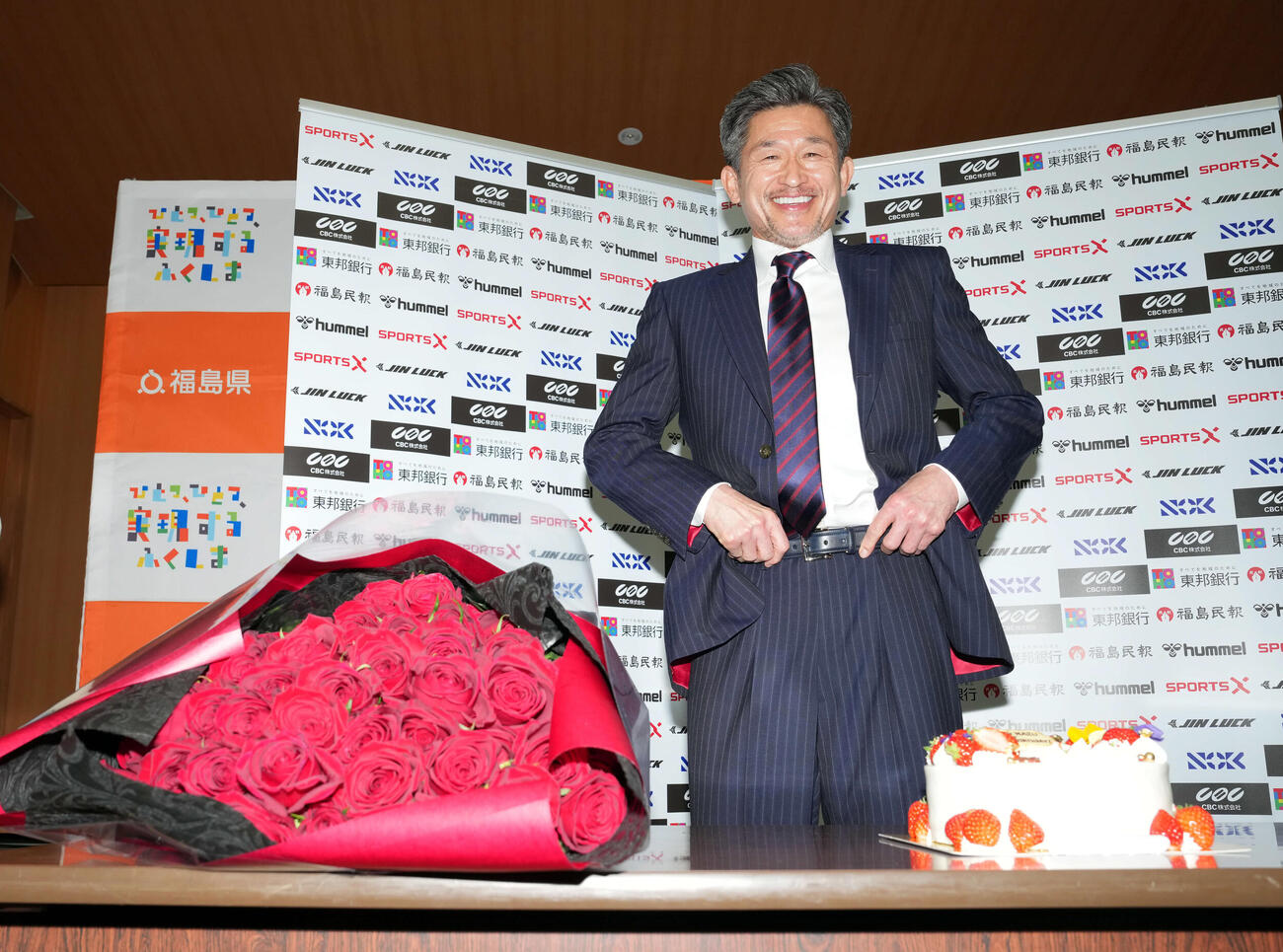 59歳を迎え、59本のバラの花束とケーキを贈られ笑顔を見せる福島カズ（撮影・たえ見朱実）