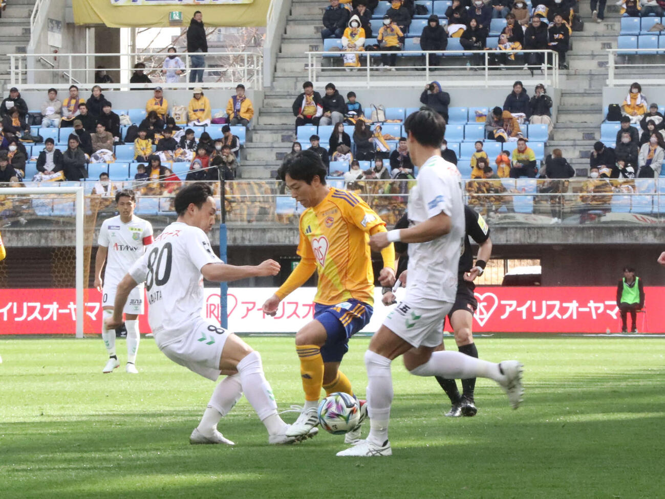 仙台対八戸　仙台MF杉山のドリブル突破を止める八戸MF永田（左）＝2026年2月28日