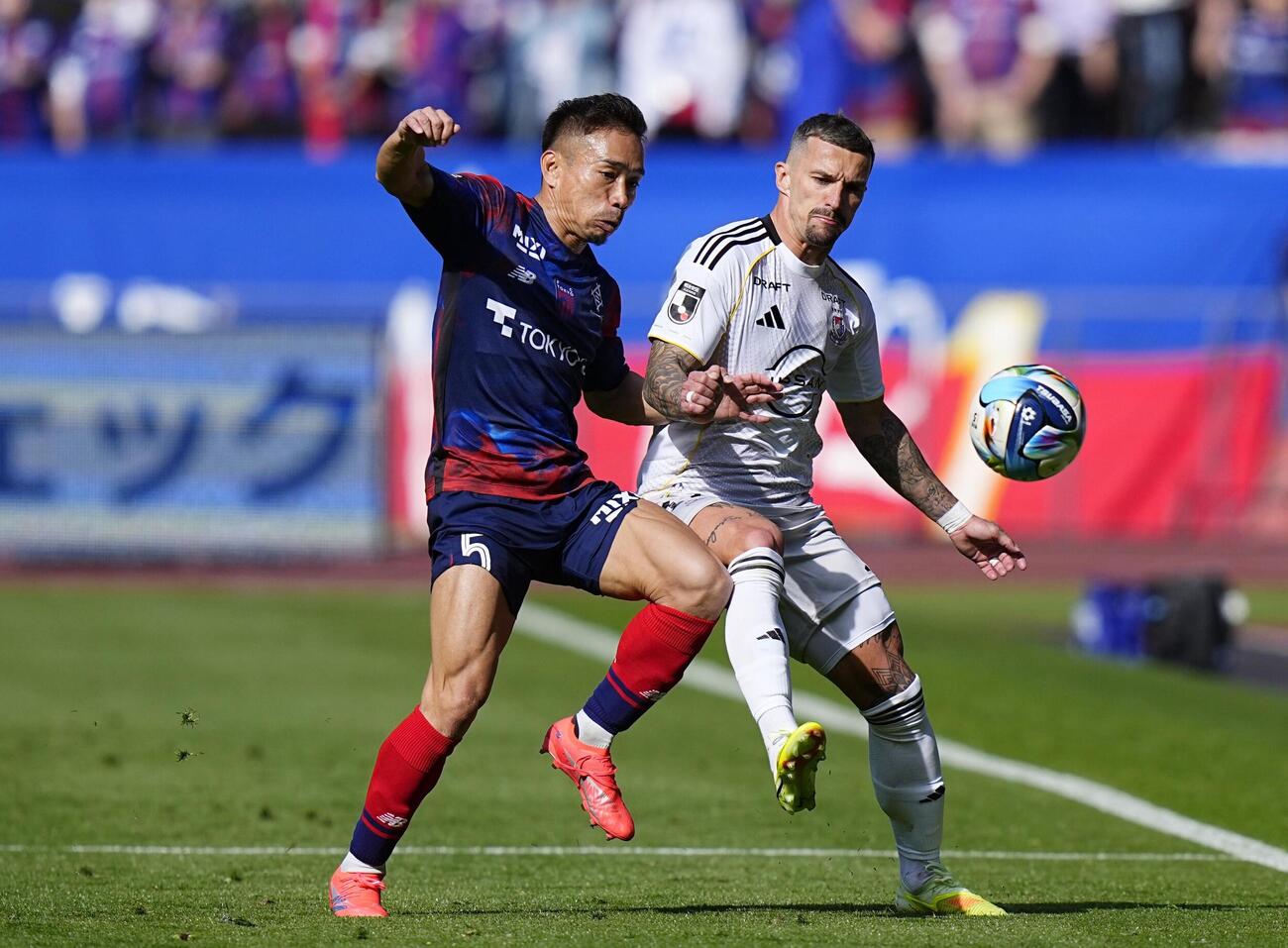 FC東京―横浜M　前半、競り合うFC東京・長友（左）と横浜Mのクルークス＝MUFG国立（共同）