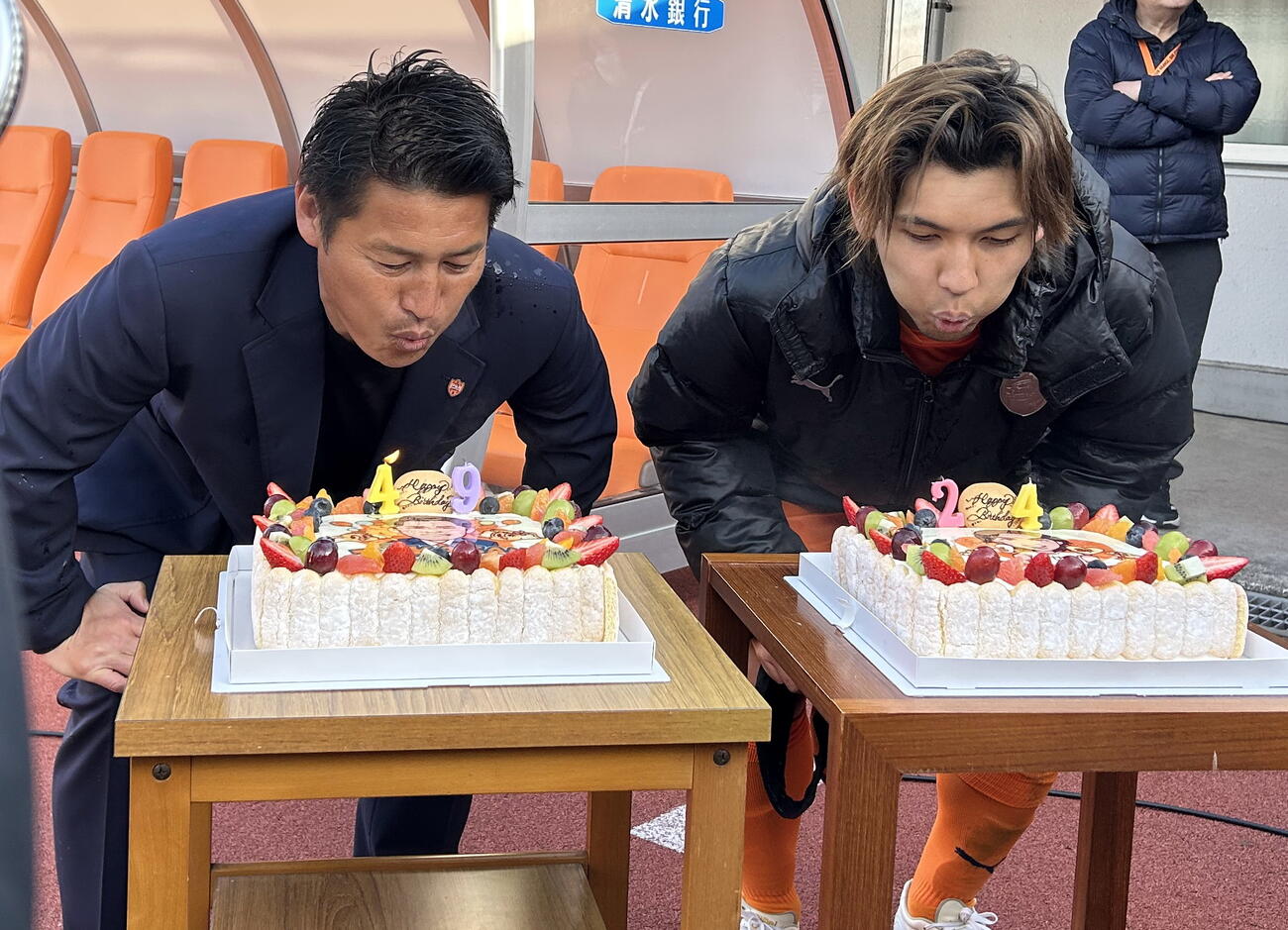試合後、誕生日ケーキのろうそくの火を消す清水吉田監督（左）と高木