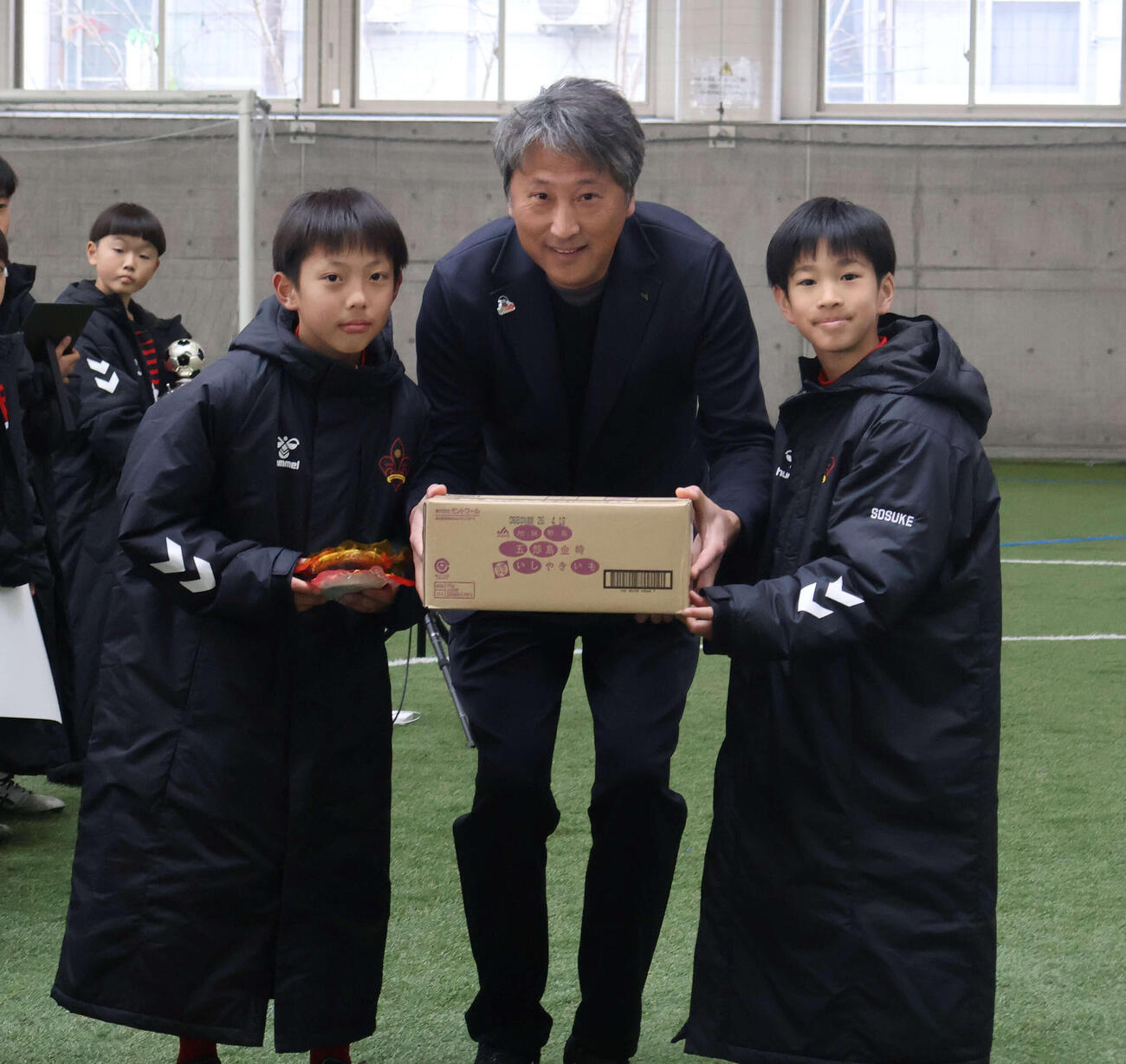 優勝チームに副賞を手渡す全農石川県本部の徳田陽一管理部長（中央）