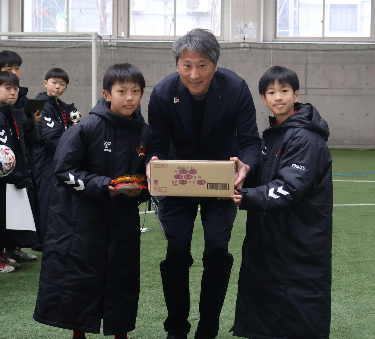 優勝チームに副賞を手渡す全農石川県本部の徳田陽一管理部長（中央）