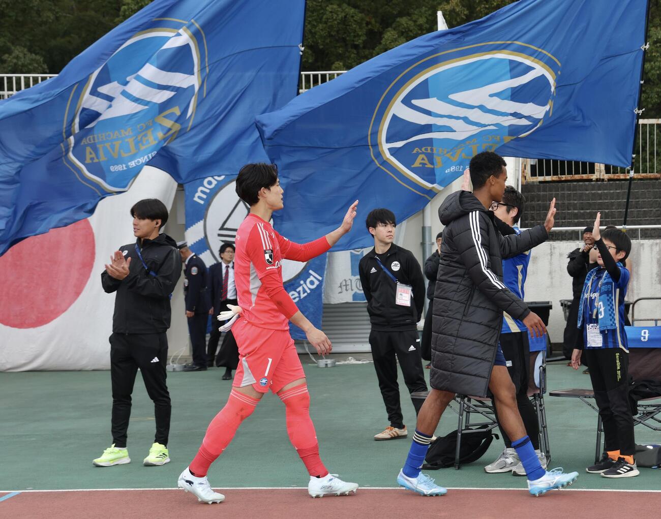 町田対川崎F　タッチを交わしながら引き揚げる町田GK谷（左）（撮影・河田真司）