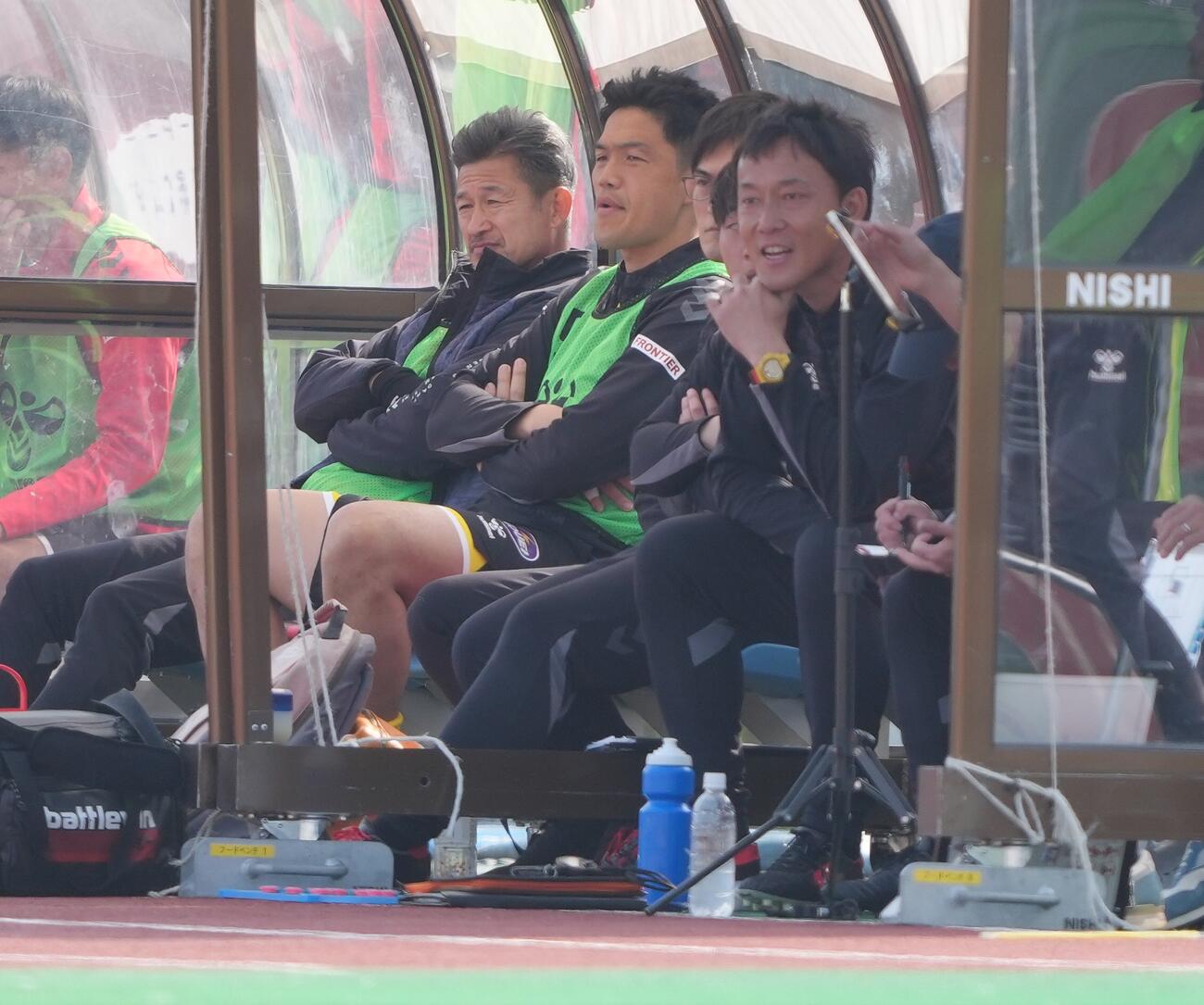 福島対松本　ベンチで試合を見つめる福島カズ（左）（撮影・足立雅史）