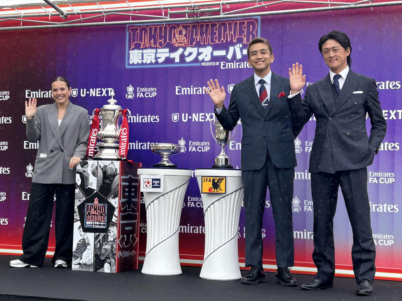 元日本代表の李忠成さん（右端）と稲本潤一さんはFAカップ（左）、天皇杯（中央）、FAシルバーカップ（右）と並び記念撮影。左端はトロフィーツアー担当のオリビア・ブザグロさん