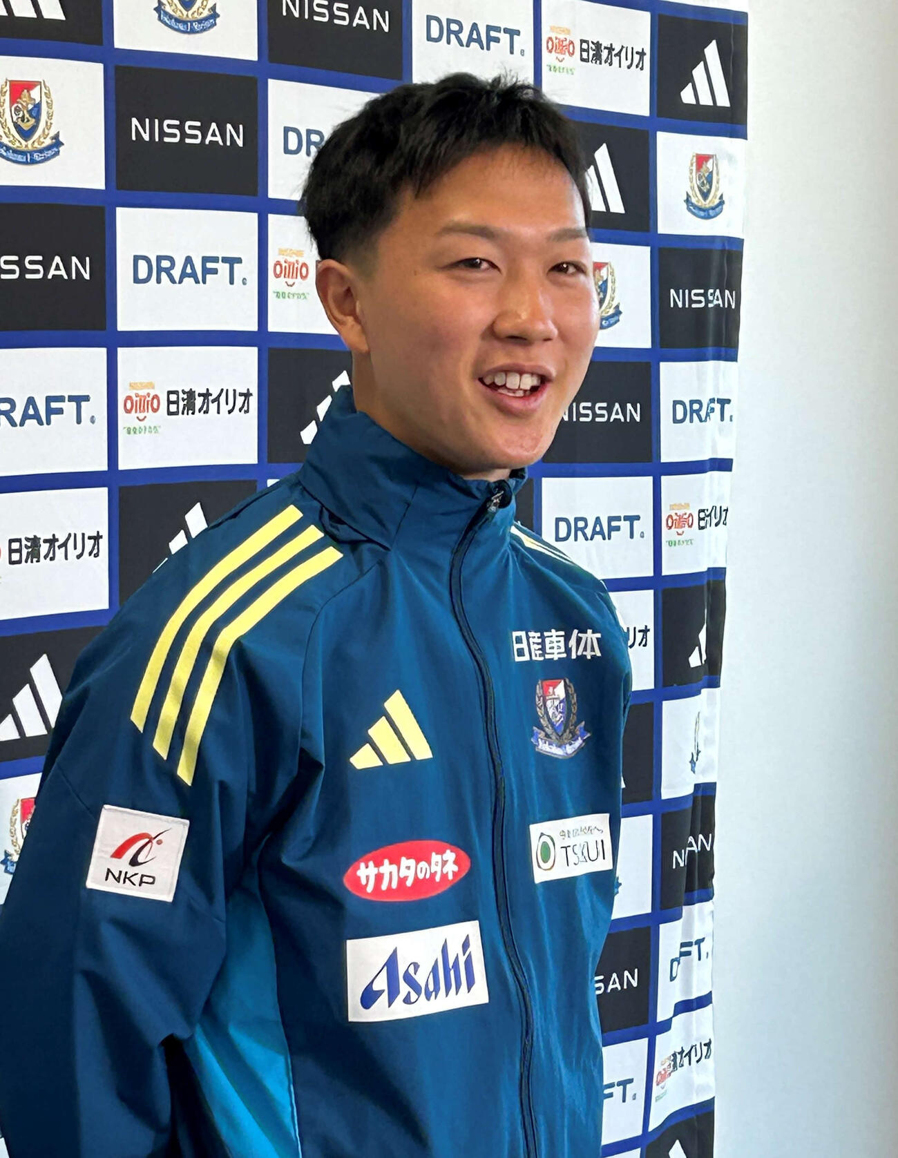16歳0日で横浜とプロ契約を結んだMF三井寺眞は会見で笑顔を見せた