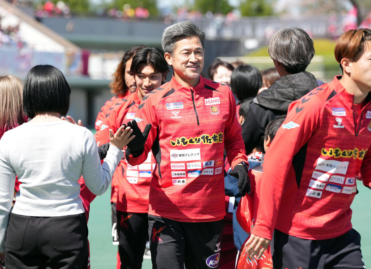 福島対いわき　サポーターとハイタッチをしてグラウンド入りする福島カズ（撮影・たえ見朱実）