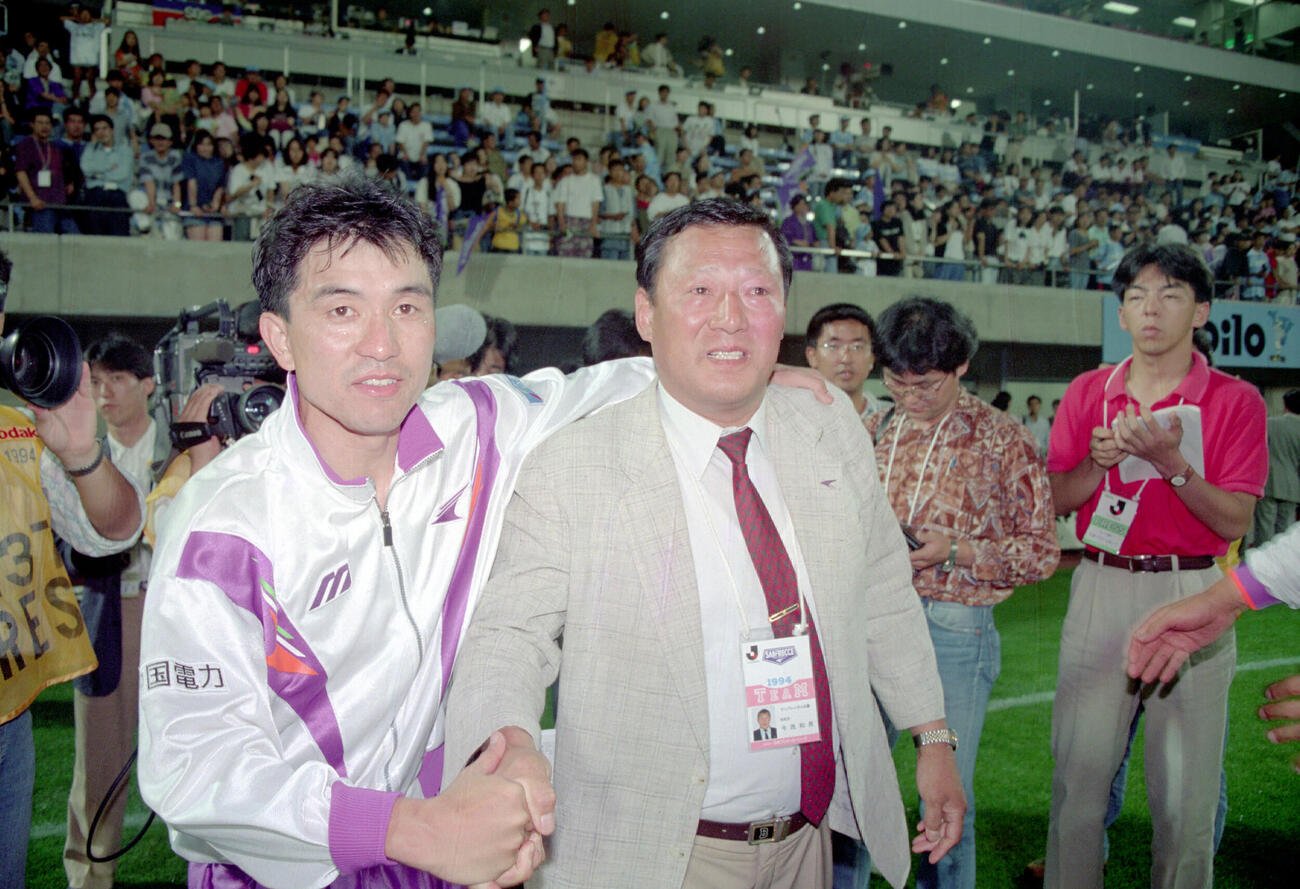 1994年、風間八宏（左）に祝福される広島の今西和男総監督