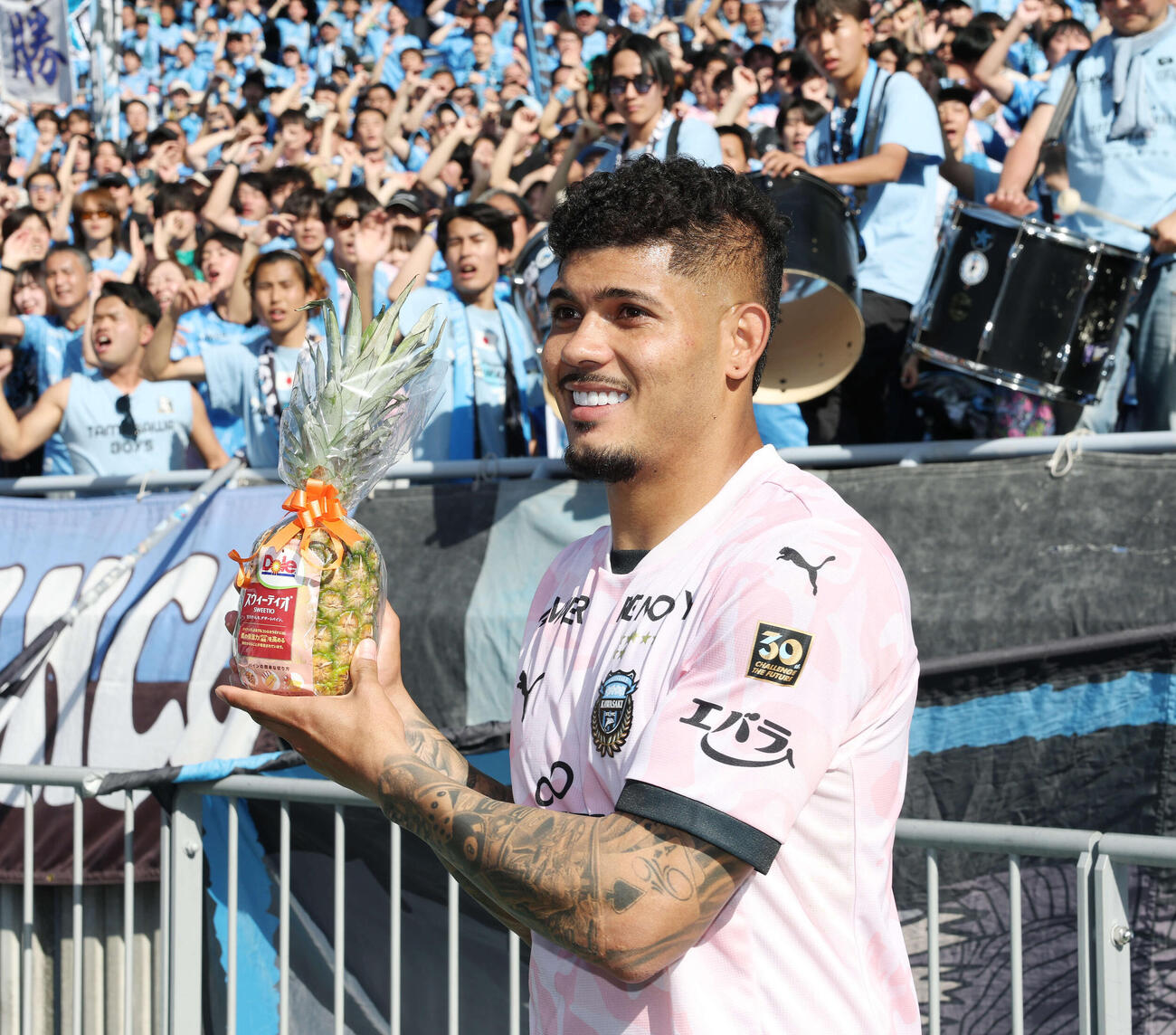 横浜対川崎F　決勝ゴールを決め勝利した川崎Fエリソンはサポーターからのパイナップルに笑顔を見せる（撮影・宮地輝）