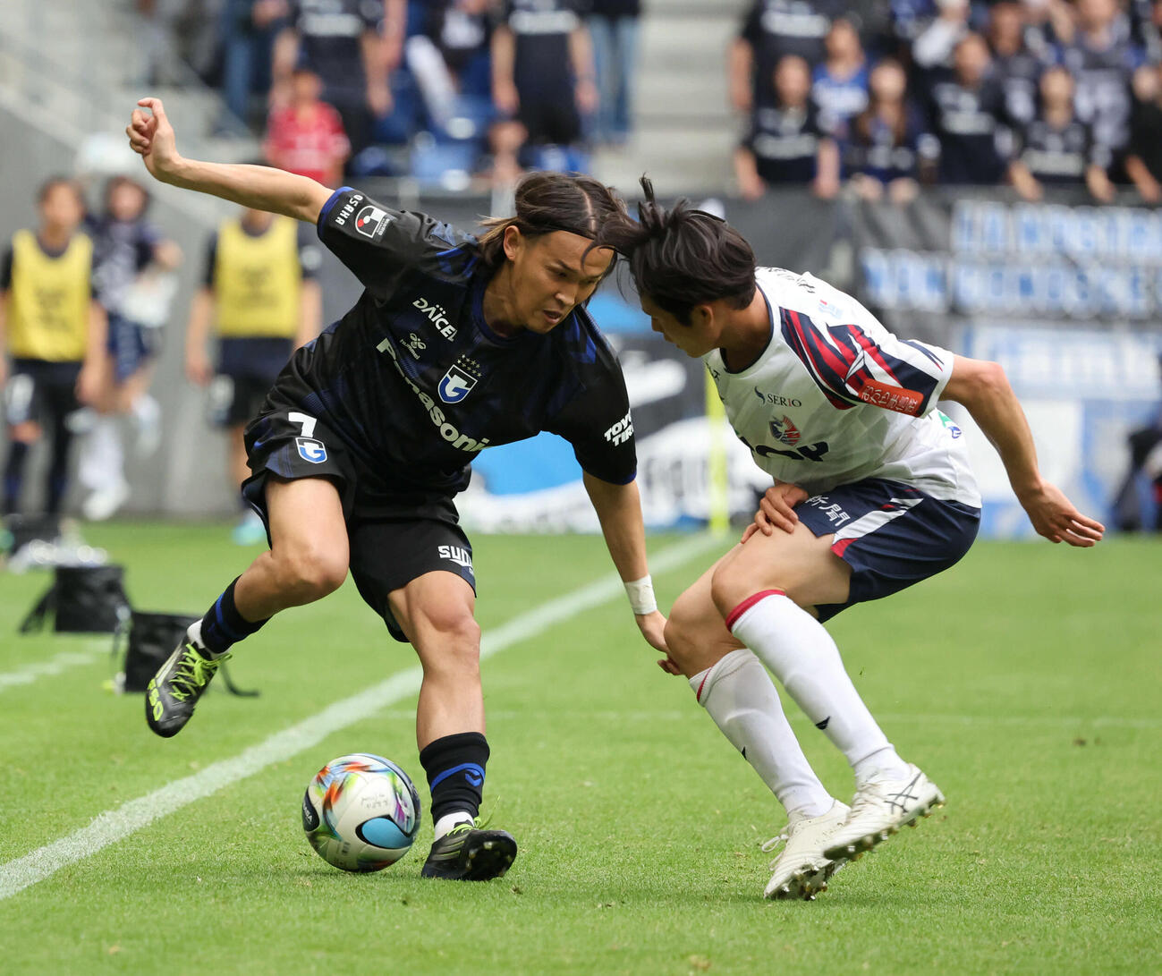 G大阪対岡山　後半、途中出場のG大阪宇佐美は岡山白井と競り合う（撮影・西尾就之）