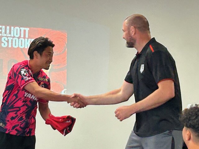 レッドハリケーンズ大阪の選手に先発のジャージーを手渡すC大阪香川