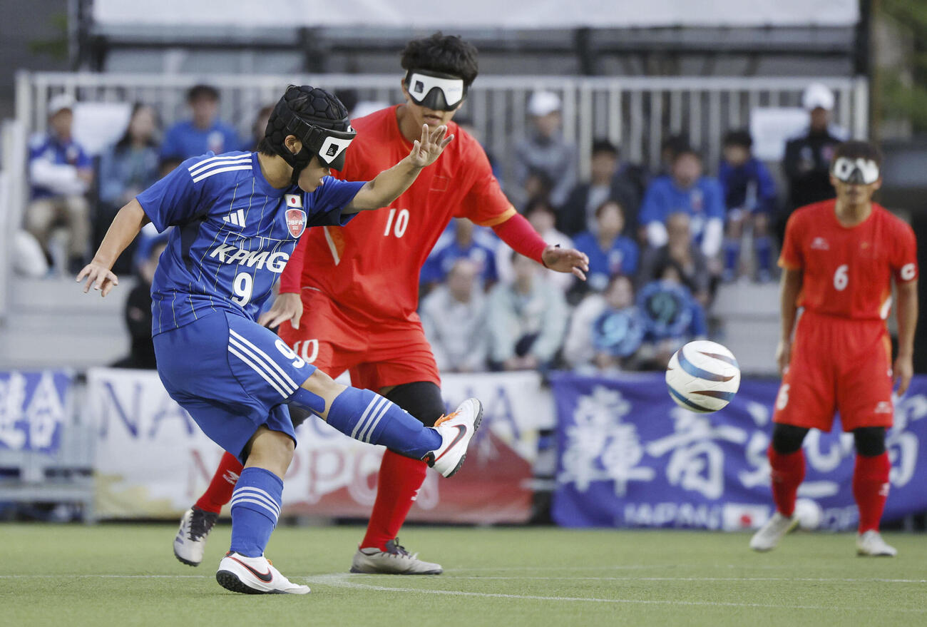 ブラインドサッカー男子のアジア選手権決勝で、攻め込む日本の平林（左）＝大阪市北区（共同）
