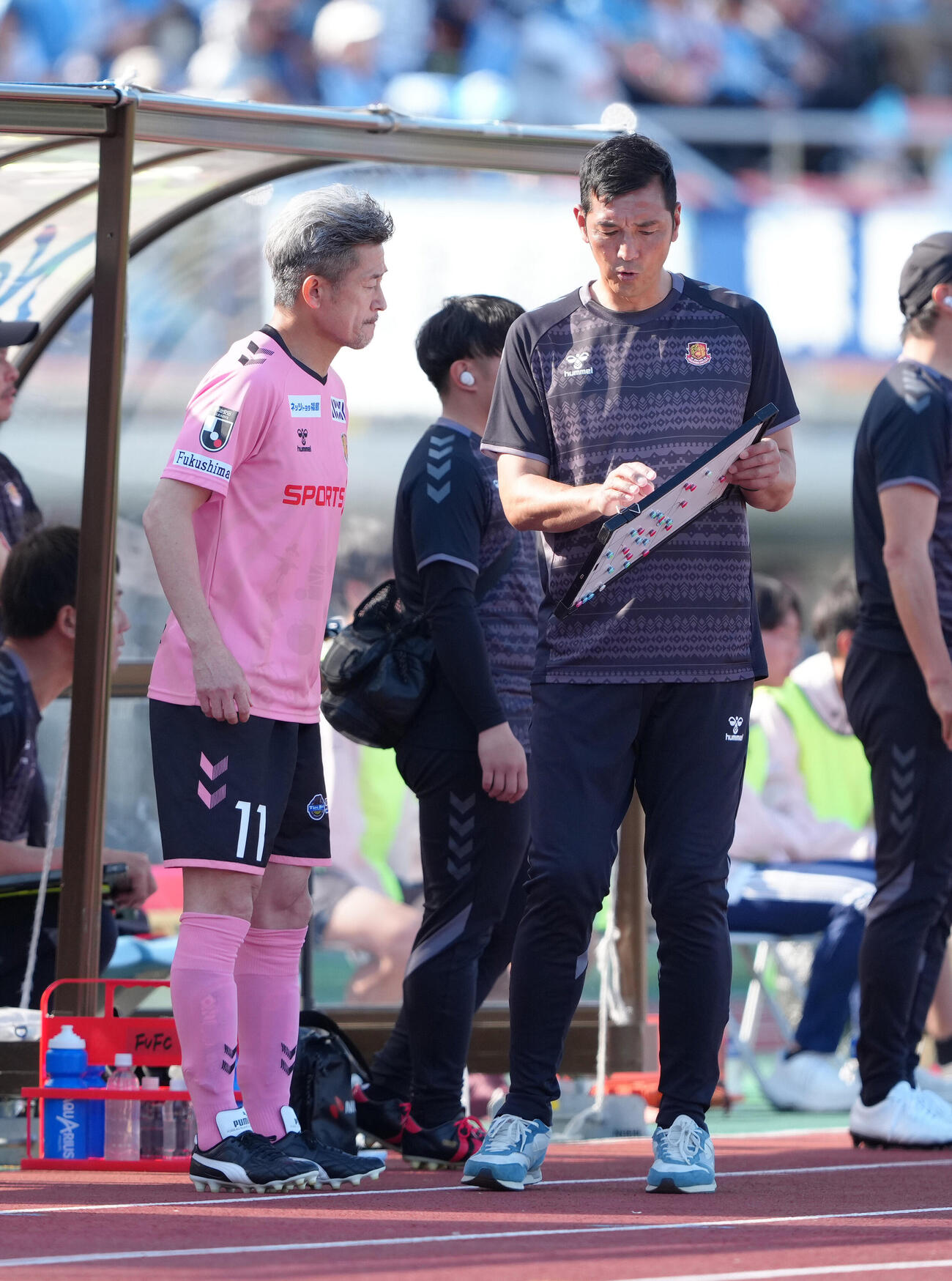 明治安田J2・J3百年構想リーグ　福島対磐田　後半、福島寺田周平監督（右）の指示を受け、交代出場の準備を進めるカズ（三浦知良）（撮影・足立雅史）