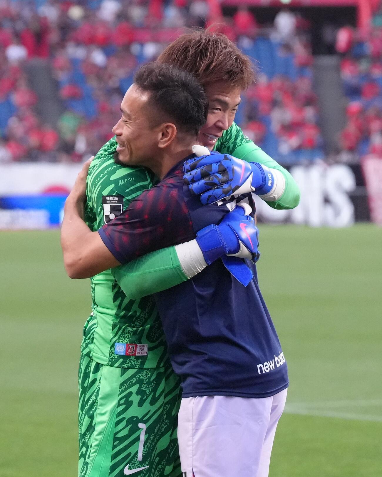 試合を終え、抱き合う東京長友佑都（右）と浦和GK西川周作（撮影・足立雅史）