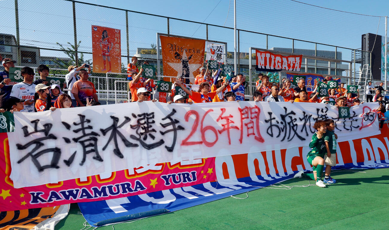 岩清水梓引退セレモニー　新潟サポーターからの横断幕前で記念撮影を行う日テレ東京V岩清水梓（右）（撮影・山本朝陽）