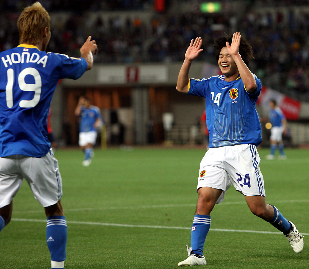 キリン杯　日本対チリ　後半ロスタイム、本田圭佑（左）のだめ押しゴールをアシストした山田直輝は笑顔でかけ寄りハイタッチ（2009年5月27日撮影）
