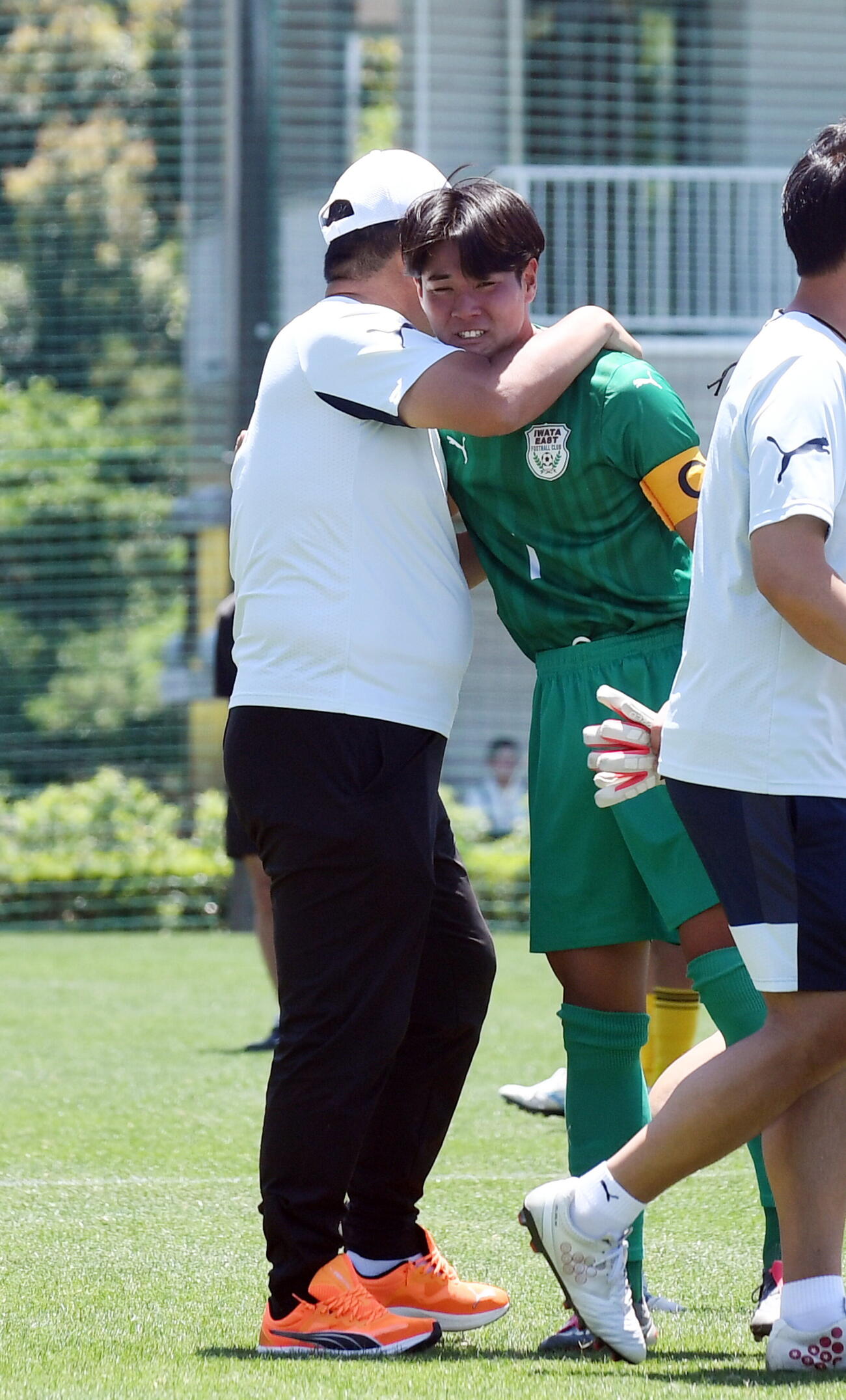 試合後、山田総監督（左）と抱き合う磐田東・小沢