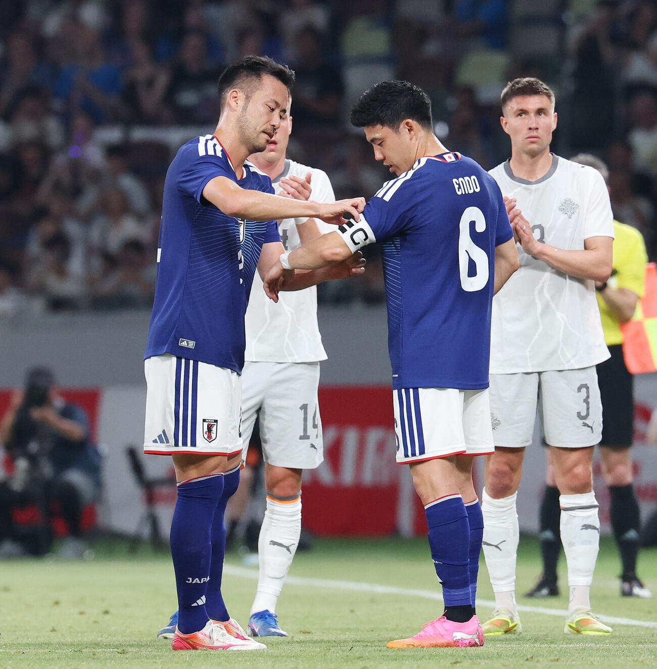 日本対アイスランド　前半、交代する吉田麻也（中央左）は遠藤航（中央）にキャプテンマークをつける（撮影・宮地輝）