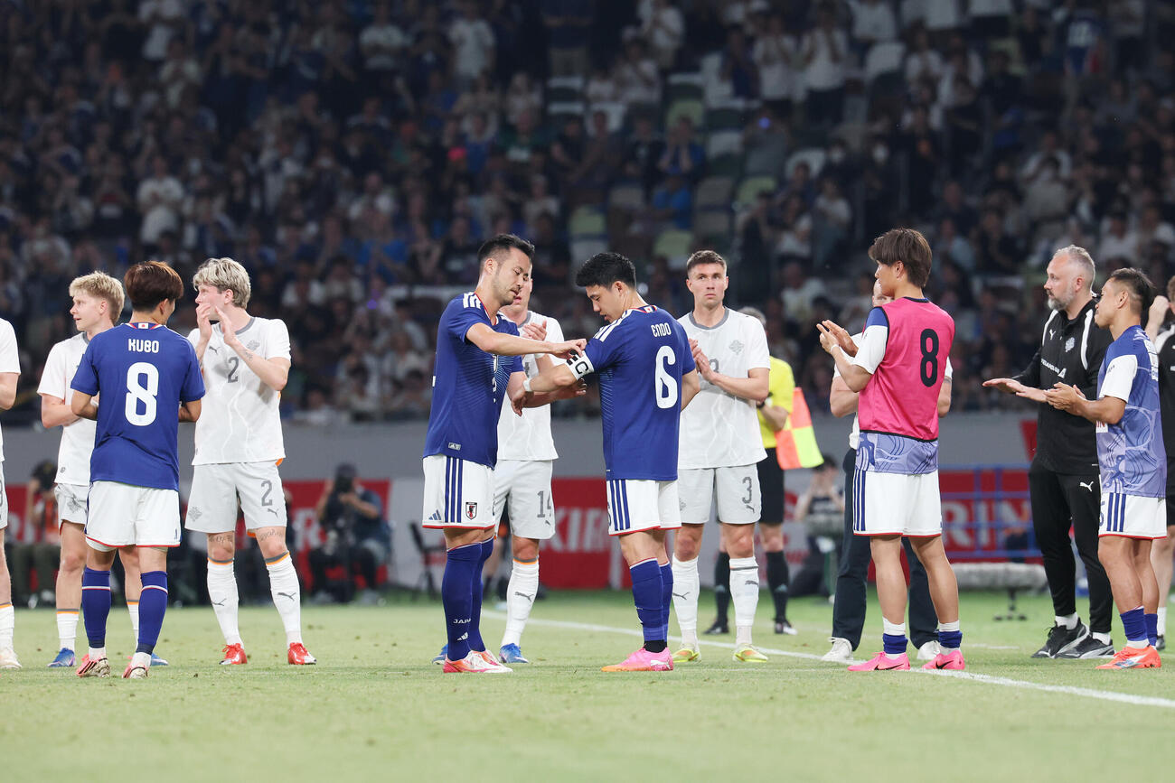 キリンチャレンジカップ2026　日本対アイスランド　前半、途中交代の吉田麻也（中央）は両チームに迎えられながらピッチを後にする（撮影・足立雅史）