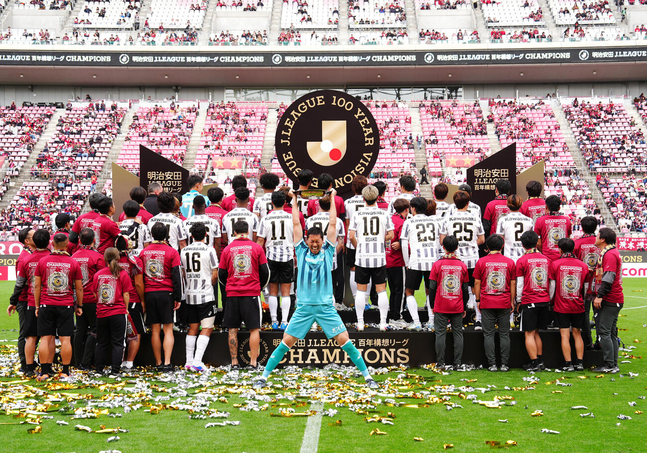 明治安田J1百年構想リーグ・プレーオフラウンド第2戦　鹿島対神戸　表彰式後、優勝シャーレを掲げる神戸GK前川黛也（中央）に背を向ける選手たち（撮影・江口和貴）