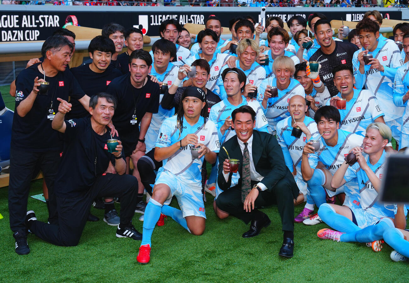 JリーグオールスターDAZNカップ　　J2・J3EAST－A対J2・J3EAST－B J2・J3EAST－A田中パウロ淳一（中央左）ら選手たちとマテ茶を手に写真に納まるJ2・J3EAST－B槙野智章監督（同右）（撮影・垰建太）